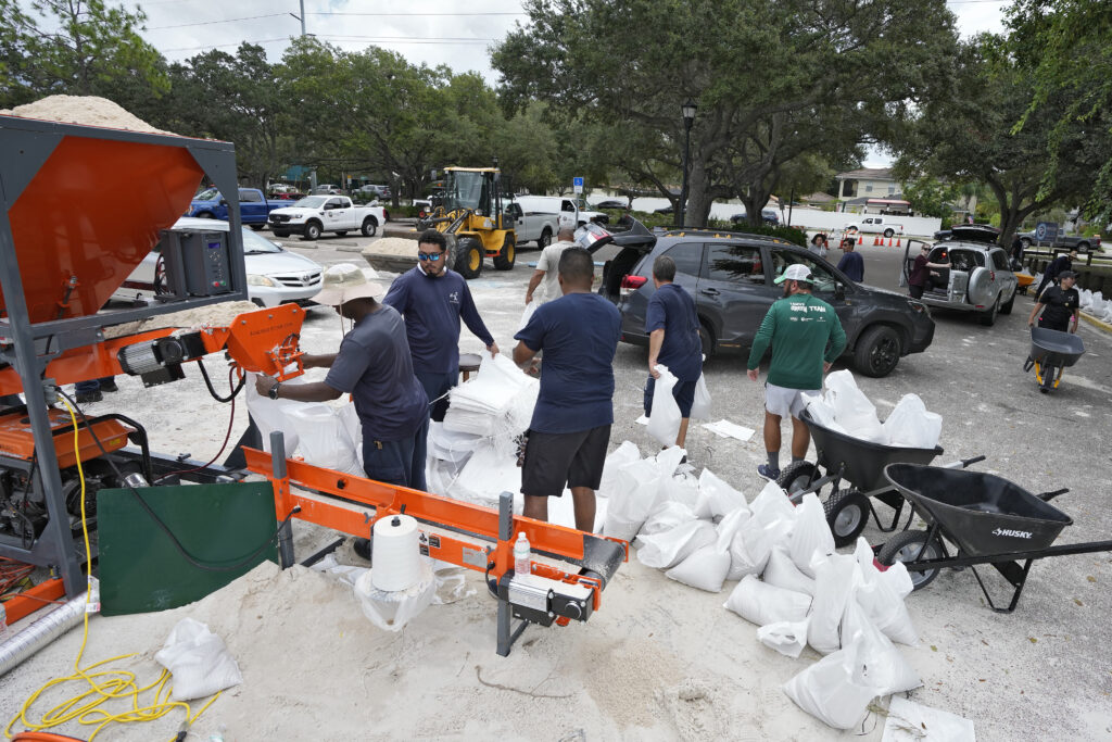 Members of the Tampa, Fla., parks and Recreation Dept., help residents with sandbags Monday, Aug. 28, 2023, in Tampa, Fla. Residents along Florida's gulf coast are making preparations for the effects of Tropical Storm Idalia. (AP Photo/Chris O'Meara)