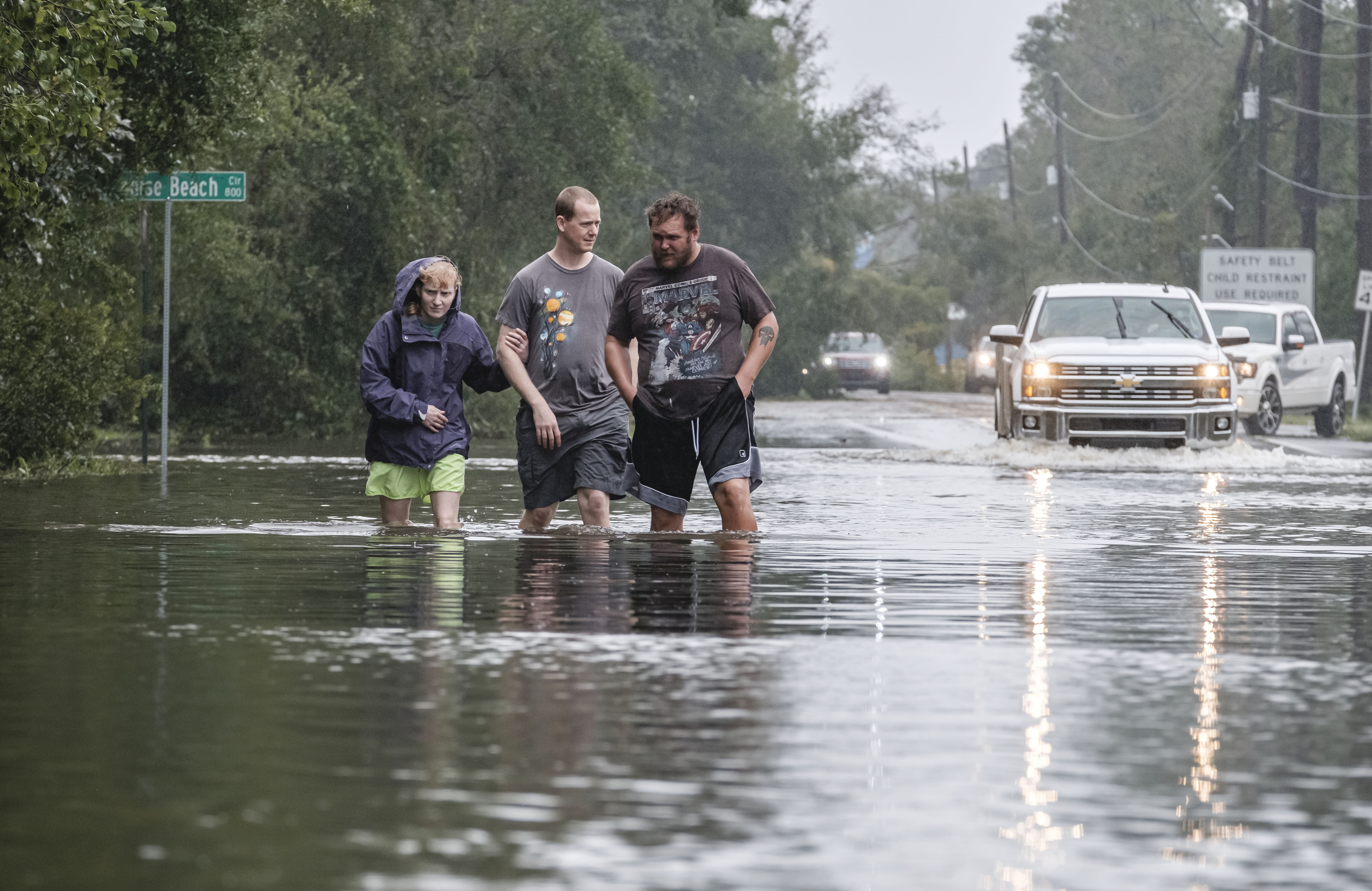 epa08674394 People walk through a road flooded out by Hurricane Sally in Paradise Beach, Florida, USA on 16 September 2020. Hurricane Sally made landfall on early 16 September as a Category 2 hurricane.  EPA-EFE/DAN ANDERSON