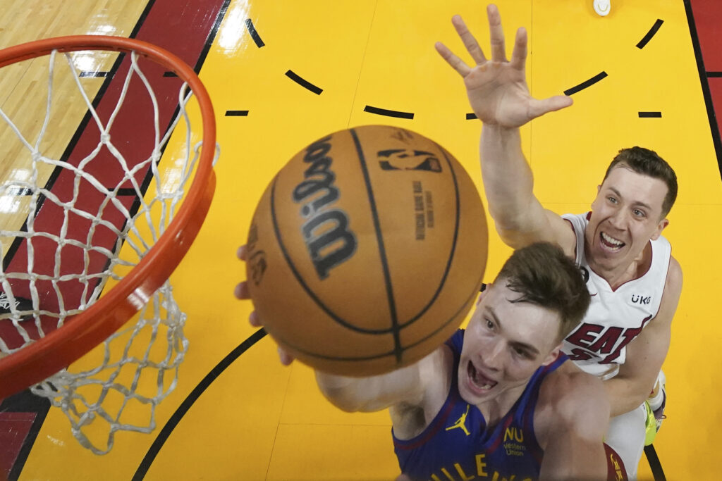 Denver Nuggets guard Christian Braun, foreground, shoots the ball against Miami Heat forward Duncan Robinson during the first half of Game 3 of the NBA Finals basketball game, Wednesday, June 7, 2023, in Miami. (Kyle Terada/Pool Photo via AP)