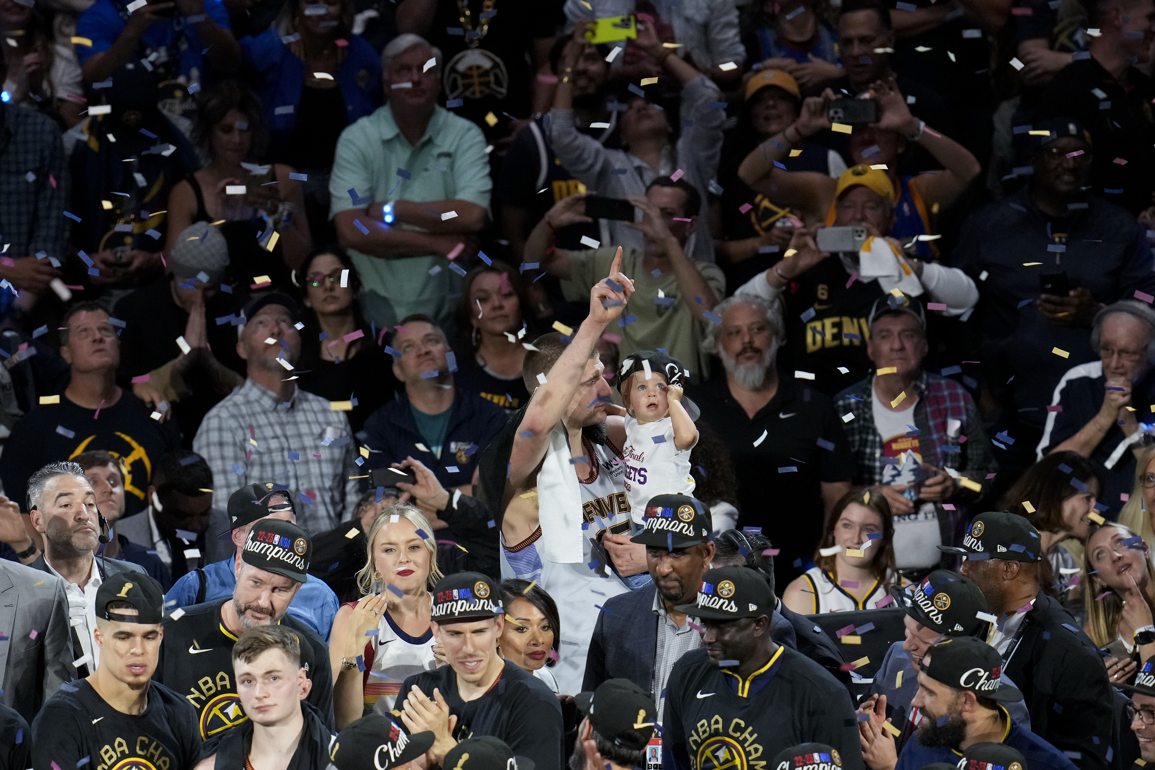 Denver Nuggets center Nikola Jokic, center, celebrates with his daughter after the team won the NBA Championship with a victory over the Miami Heat in Game 5 of basketball's NBA Finals, Monday, June 12, 2023, in Denver. (AP Photo/David Zalubowski)