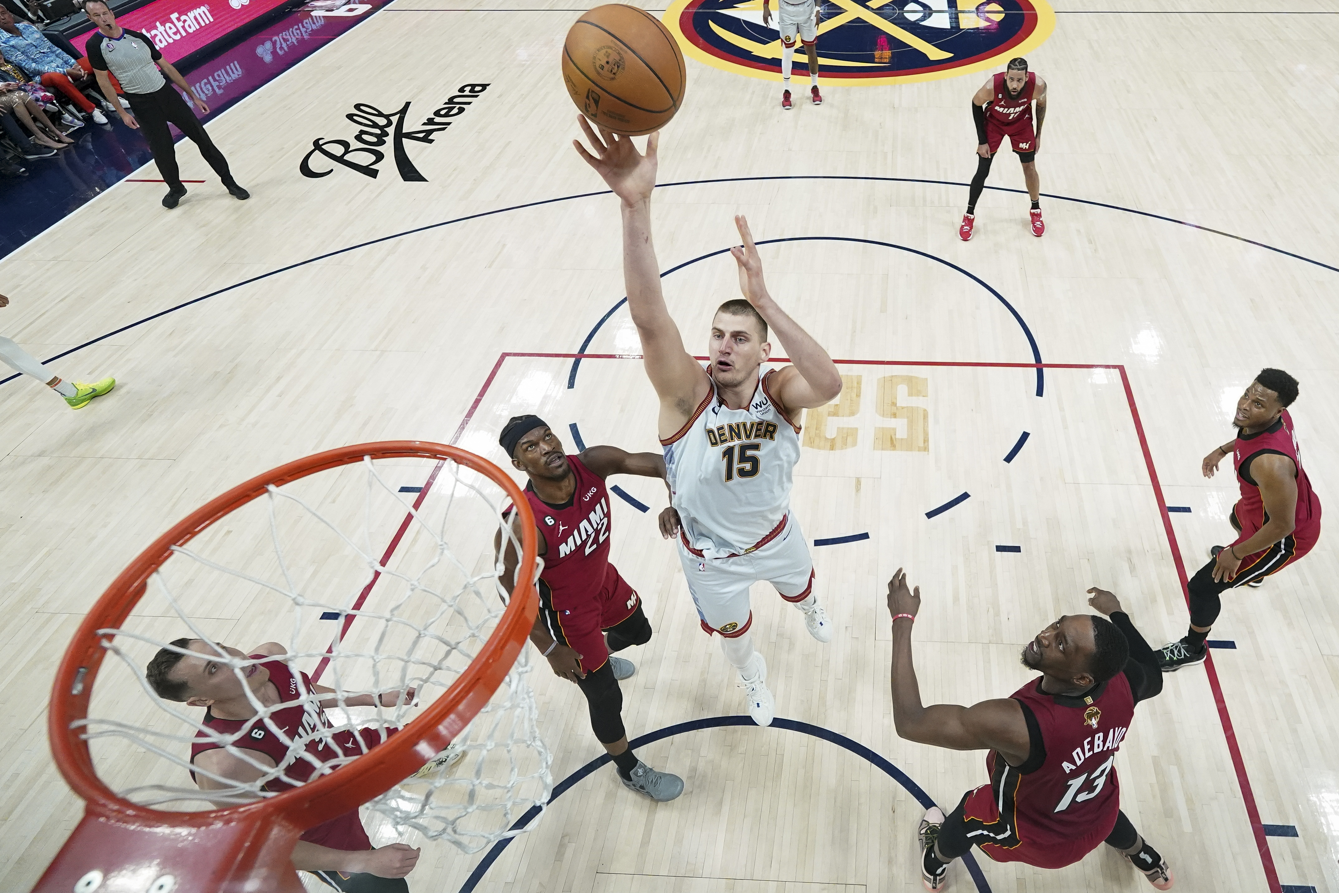 Denver Nuggets center Nikola Jokic (15) shoots next to Miami Heat forward Jimmy Butler (22) during the first half of Game 2 of basketball's NBA Finals, Monday, June 12, 2023, in Denver. (AP Photo/Jack Dempsey, Pool)
