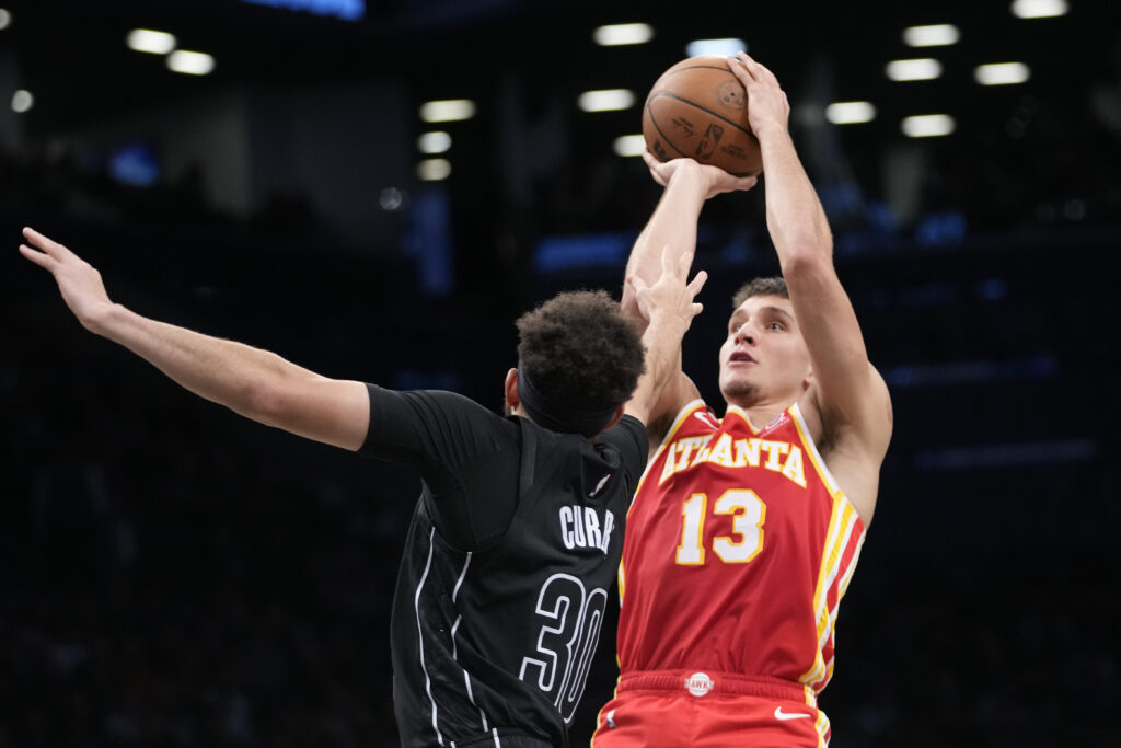 Atlanta Hawks guard Bogdan Bogdanovic (13) shoots against Brooklyn Nets guard Seth Curry (30) during the first half of an NBA basketball game Friday, March 31, 2023, in New York. (AP Photo/Mary Altaffer)