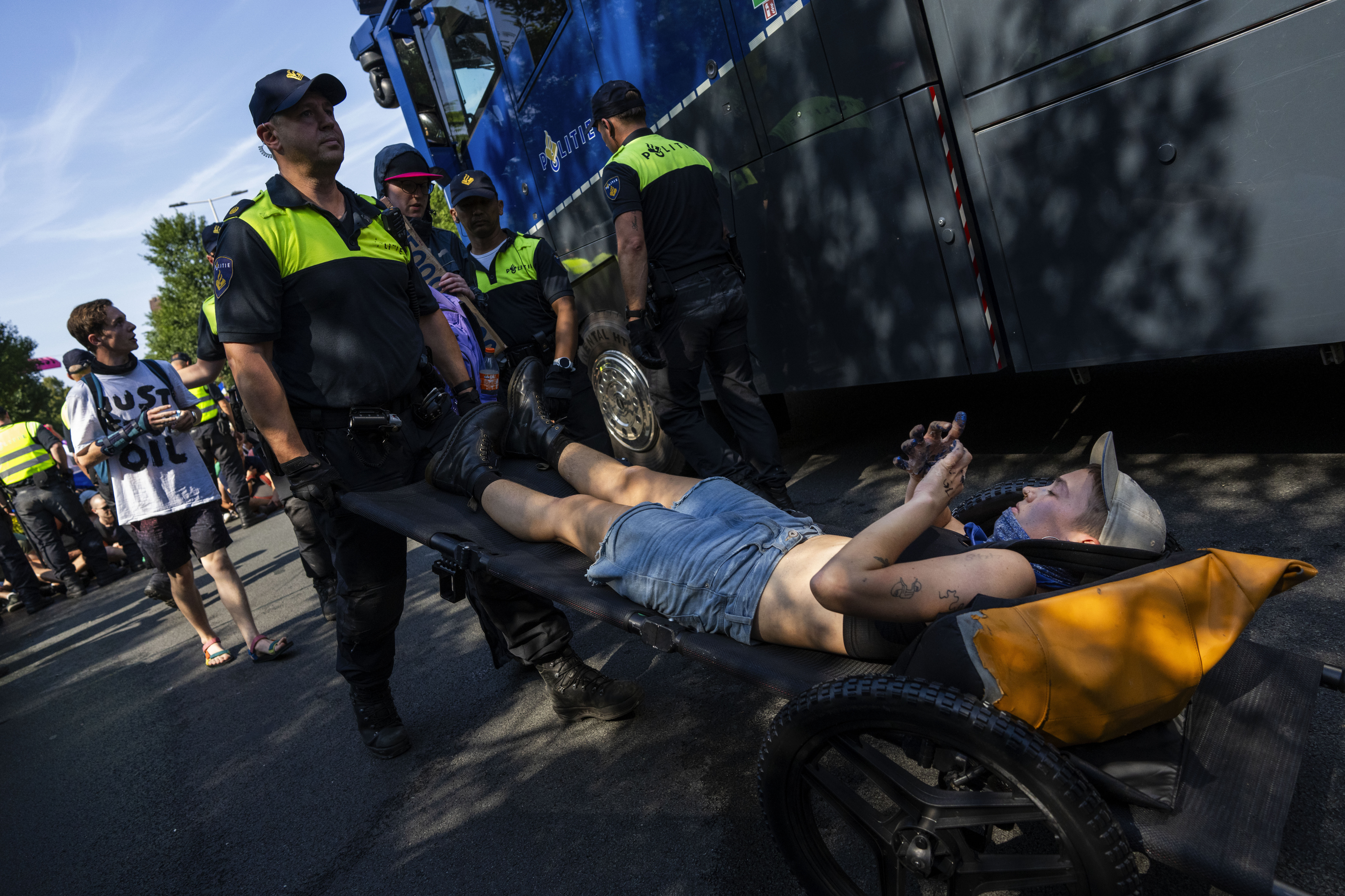 Arrested protestors are wheeled of by Dutch police after blocking a highway during a climate protest of Extinction Rebellion and other activists near the Dutch parliament in The Hague, Netherlands, Saturday, Sept. 9, 2023. (AP Photo/Peter Dejong)