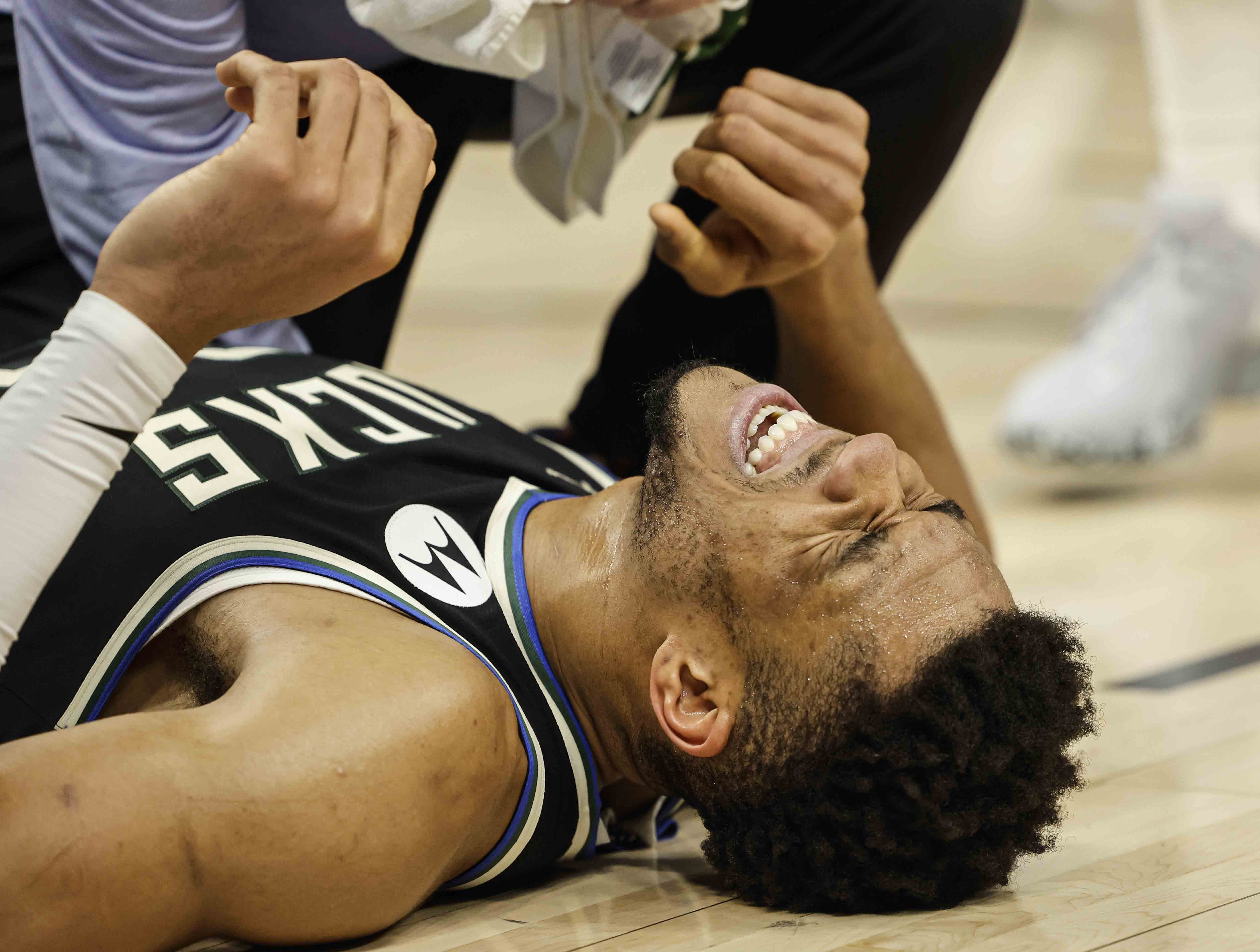 Milwaukee Bucks forward Giannis Antetokounmpo grimaces after getting injured while playing against the Boston Celtics during an NBA basketball game, Tuesday, Feb. 14, 2023, in Milwaukee. (AP Photo/Jeffrey Phelps)