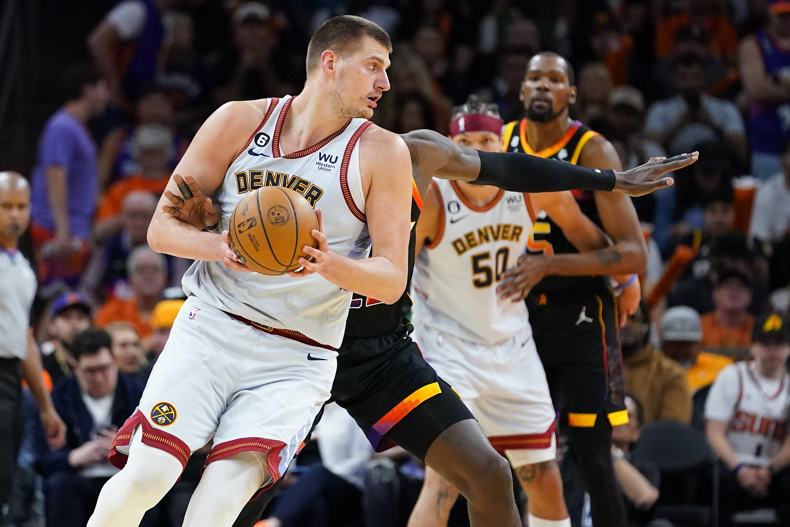 Denver Nuggets center Nikola Jokic backs down Phoenix Suns center Deandre Ayton during the first half of Game 3 of an NBA basketball Western Conference semifinal game, Friday, May 5, 2023, in Phoenix. (AP Photo/Matt York)