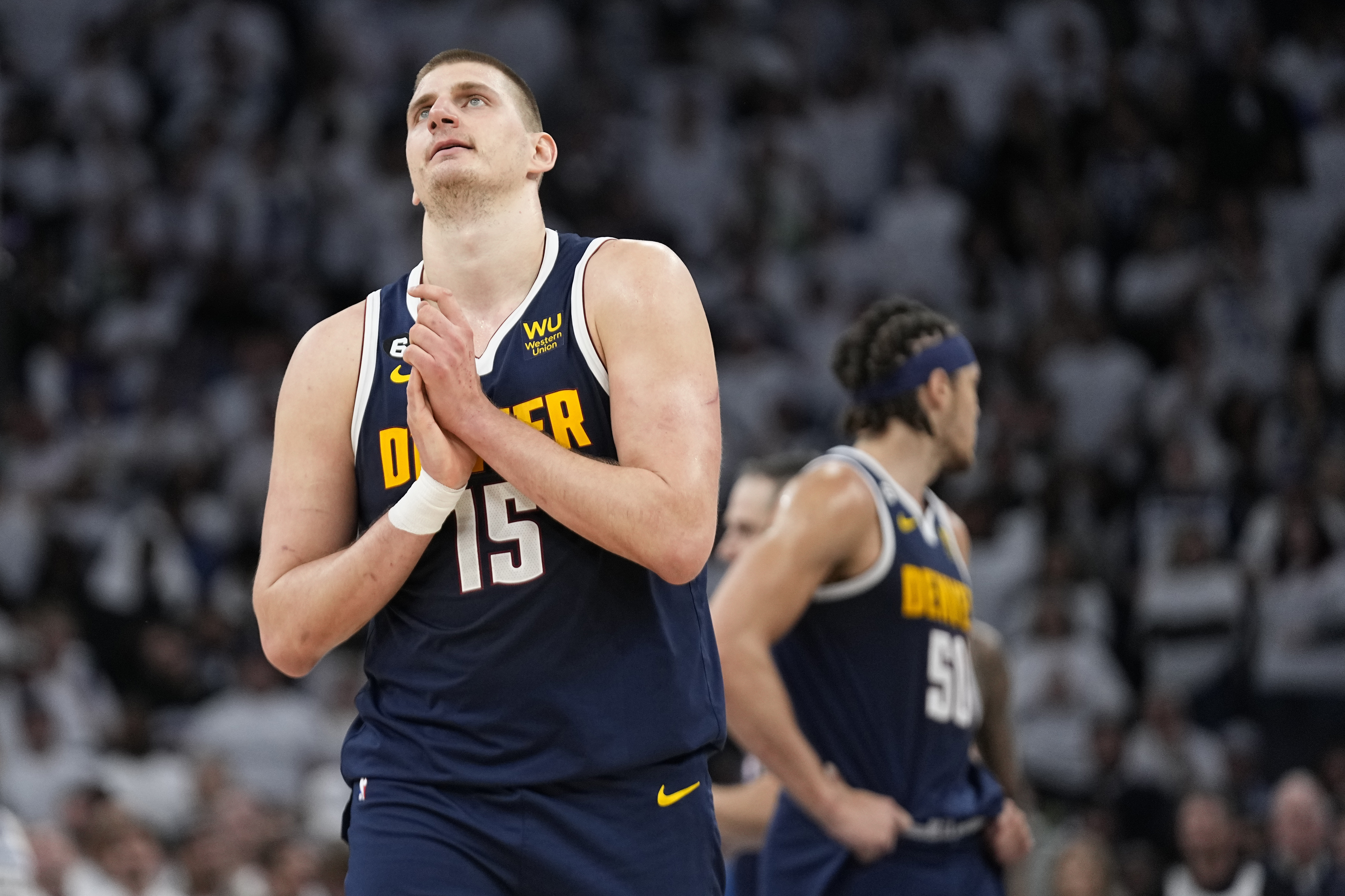 Denver Nuggets center Nikola Jokic (15) walks towards the team bench during overtime of Game 4 of an NBA basketball first-round playoff series against the Minnesota Timberwolves, Sunday, April 23, 2023, in Minneapolis. (AP Photo/Abbie Parr)
