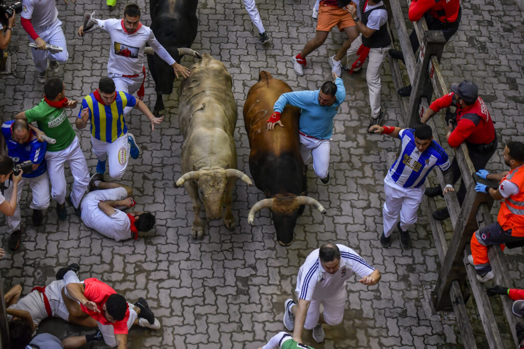 Fuente Ymbro's fighting bulls run among revellers during the fourth day of the running of the bulls during the San Fermin fiestas in Pamplona, Spain, Monday, July 10, 2023. (AP Photo/Alvaro Barrientos)