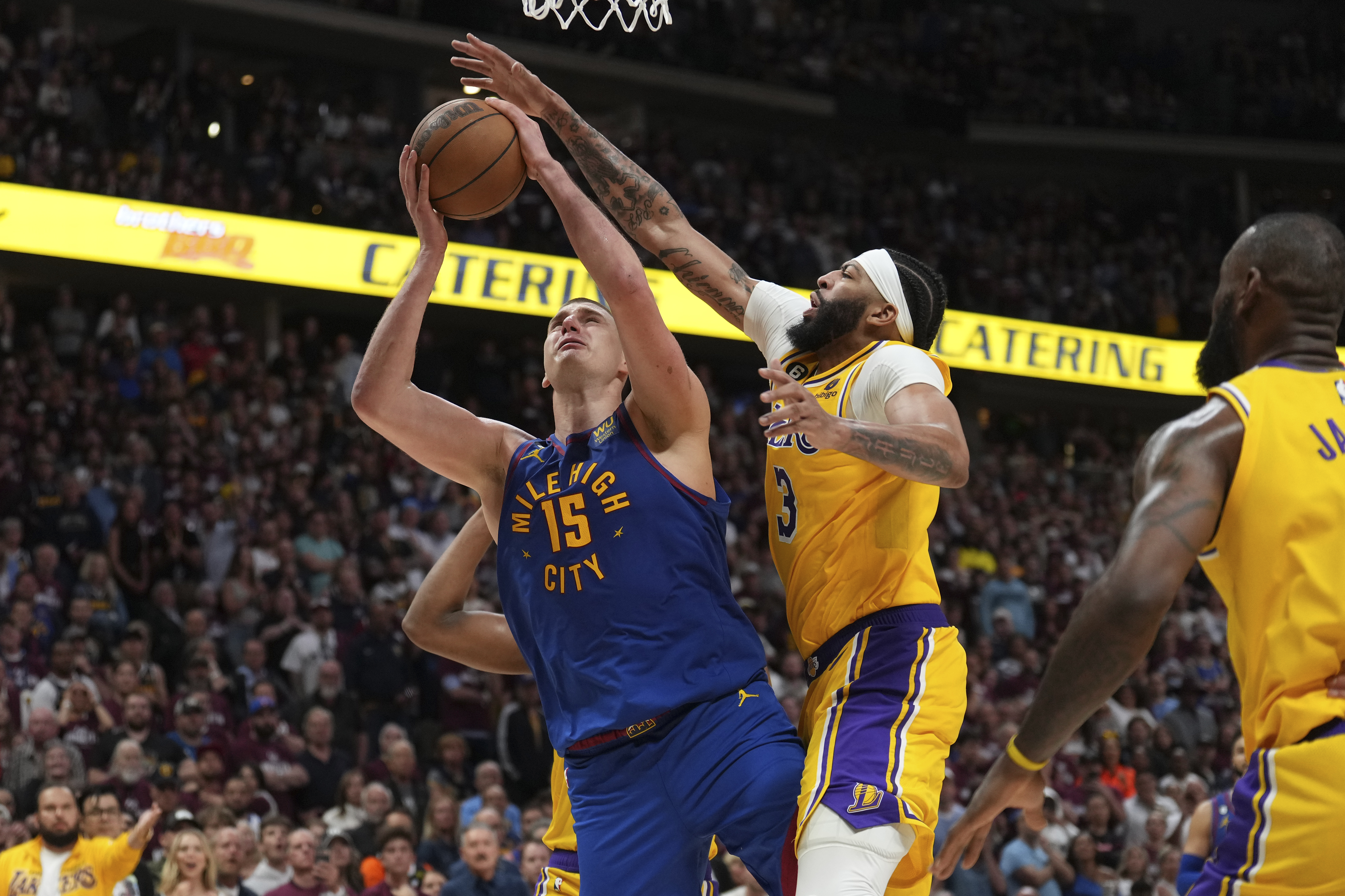 Denver Nuggets center Nikola Jokic (15) shoots over Los Angeles Lakers forward Anthony Davis (3) during the second half of Game 1 of the NBA basketball Western Conference Finals series, Tuesday, May 16, 2023, in Denver. (AP Photo/Jack Dempsey)