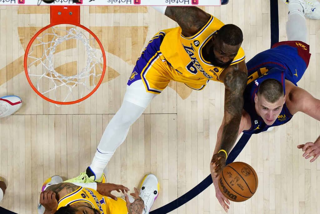 Denver Nuggets center Nikola Jokic, right, and Los Angeles Lakers forward LeBron James battle for a rebound during the second half of Game 1 of the NBA basketball Western Conference Finals series, Tuesday, May 16, 2023, in Denver. (AP Photo/Jack Dempsey)