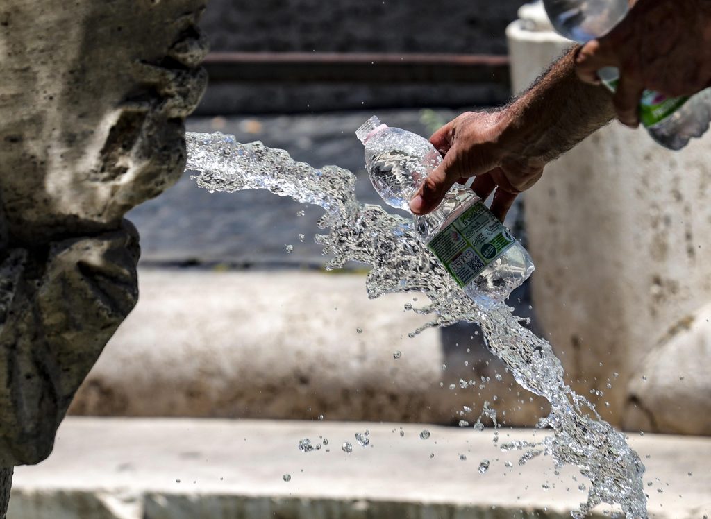 flasica voda vrucina epa10081943 Tourists cool off during a hot day in Rome, Italy, 20 July 2022. A heatwave hits Italy with temperatures between 30 and 40 degrees Celsius in many parts of the country.  EPA-EFE/GIUSEPPE LAMI