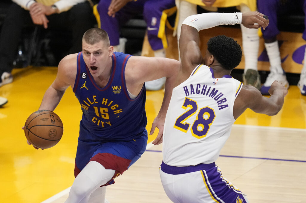 Denver Nuggets center Nikola Jokic (15) dribbles past Los Angeles Lakers forward Rui Hachimura (28) in the second half of Game 3 of the NBA basketball Western Conference Final series Saturday, May 20, 2023, in Los Angeles. (AP Photo/Ashley Landis)