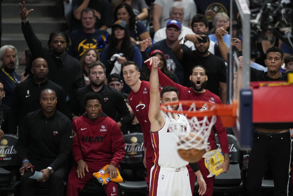 Miami Heat guard Max Strus, center, makes a 3-point basket against the Denver Nuggets during the first half of Game 2 of basketball's NBA Finals, Sunday, June 4, 2023, in Denver. (AP Photo/Mark J. Terrill)