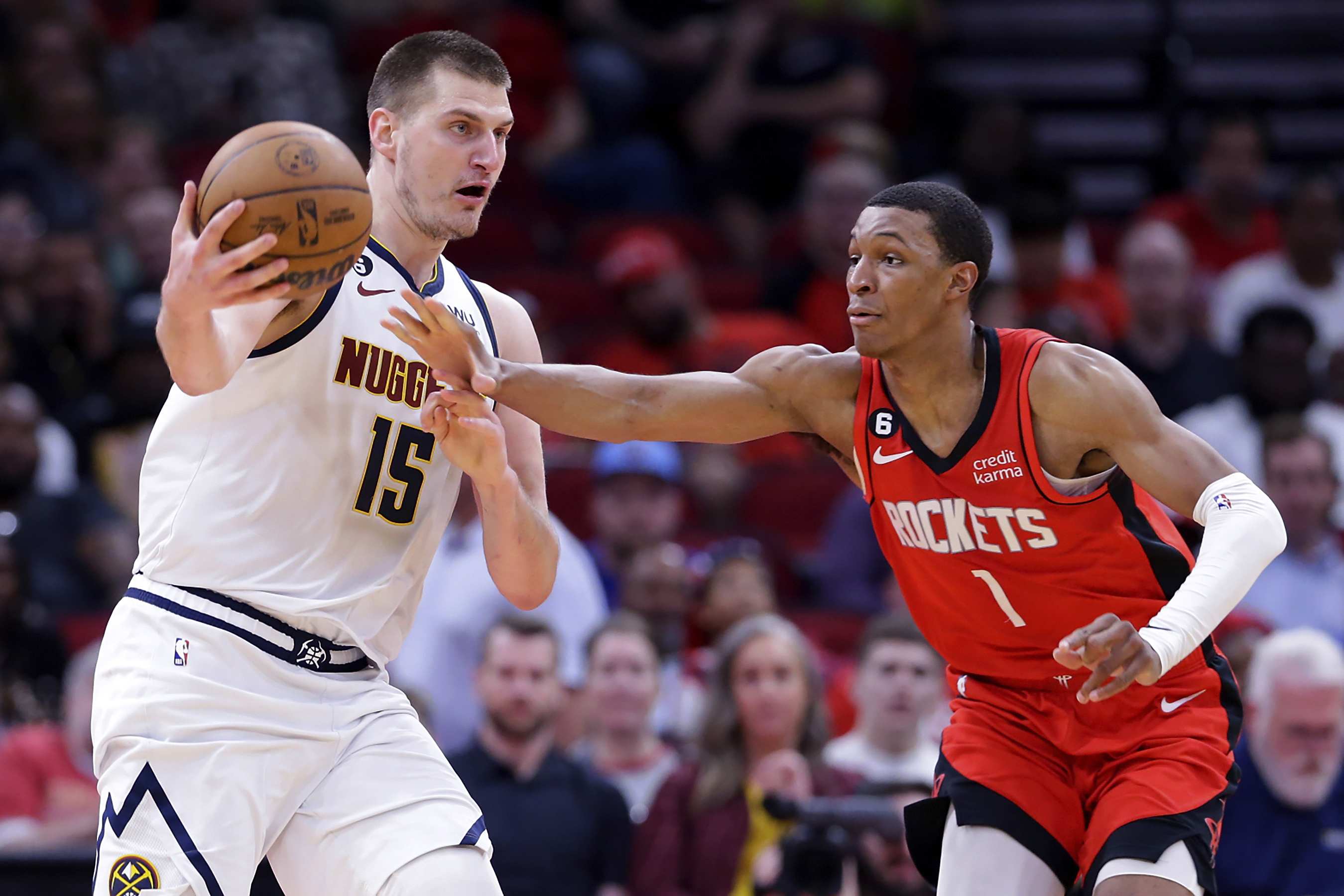 Houston Rockets forward Jabari Smith Jr. (1) reaches for the ball as Denver Nuggets center Nikola Jokic (15) looks to pass it during the second half of an NBA basketball game Tuesday, April 4, 2023, in Houston. (AP Photo/Michael Wyke)