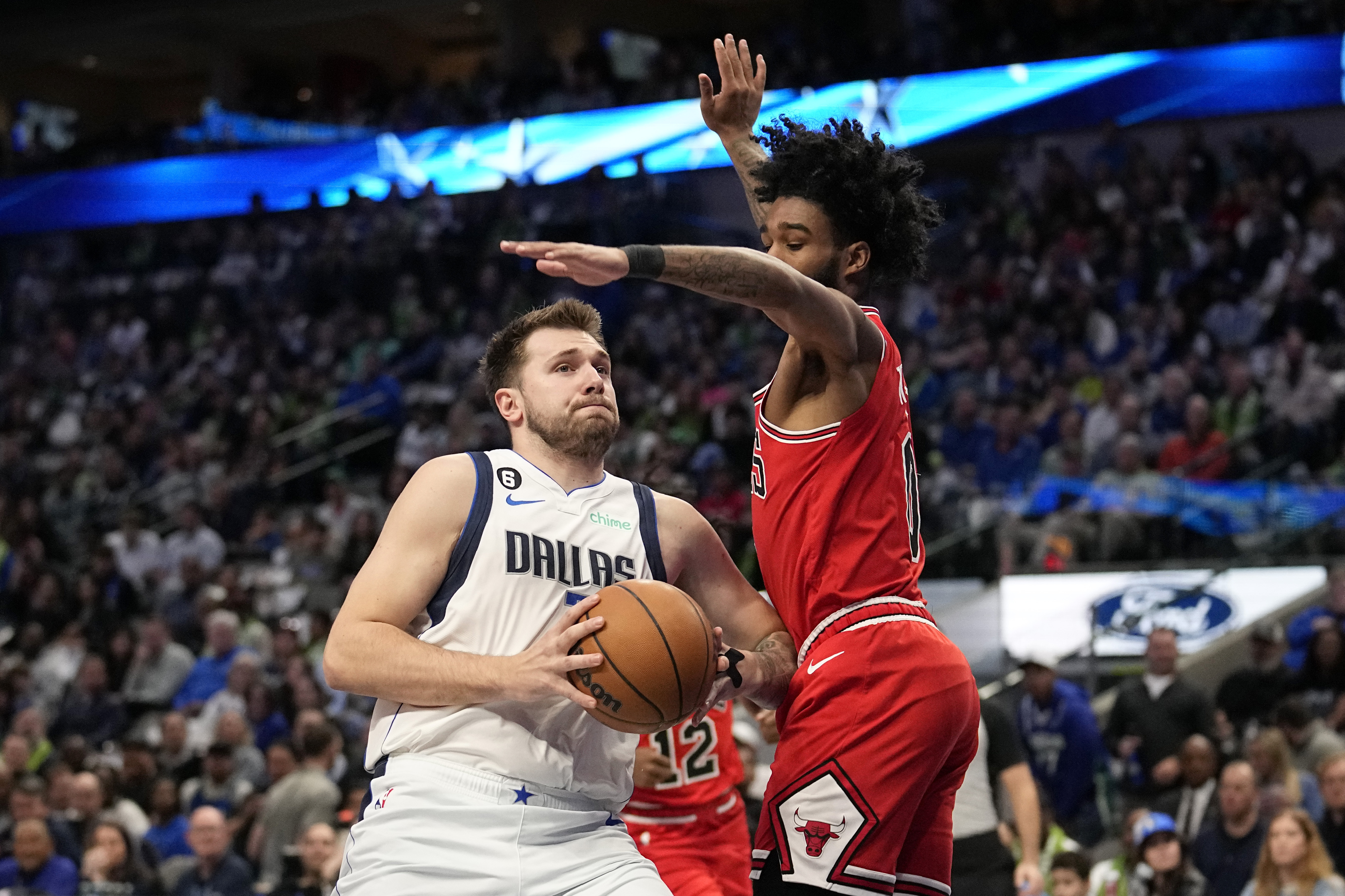 Dallas Mavericks guard Luka Doncic, left, drives to the basket as Chicago Bulls guard Coby White, right, defends in the first half of an NBA basketball game, Friday, April 7, 2023, in Dallas. (AP Photo/Tony Gutierrez)