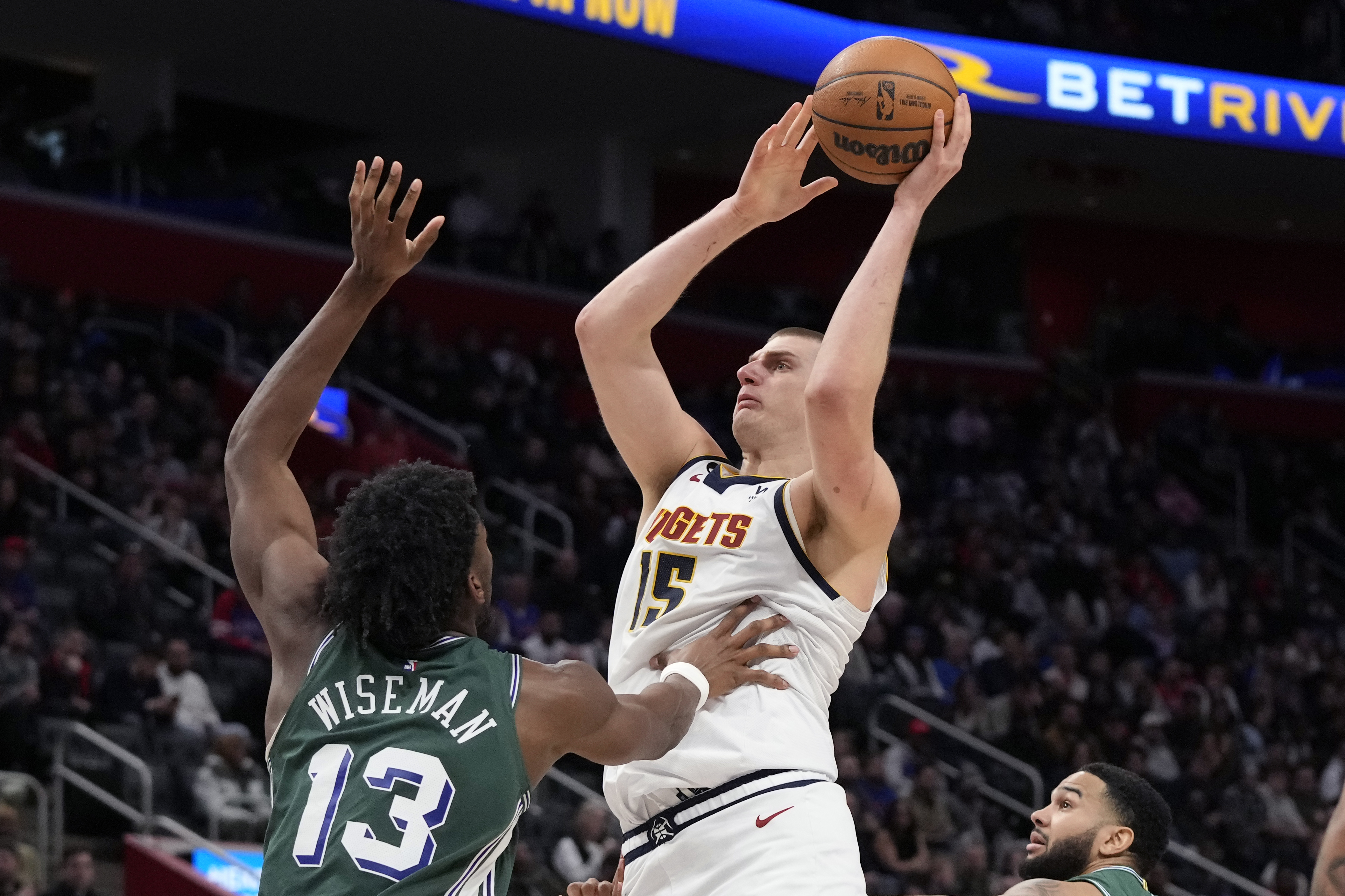 Denver Nuggets center Nikola Jokic (15) shoots over Detroit Pistons center James Wiseman (13) during the second half of an NBA basketball game, Thursday, March 16, 2023, in Detroit. (AP Photo/Carlos Osorio)