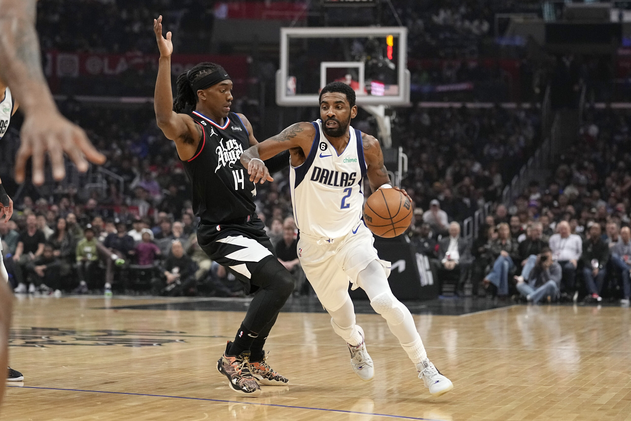Dallas Mavericks guard Kyrie Irving, right, drives past Los Angeles Clippers guard Terance Mann during the first half of an NBA basketball game Wednesday, Feb. 8, 2023, in Los Angeles. (AP Photo/Mark J. Terrill)