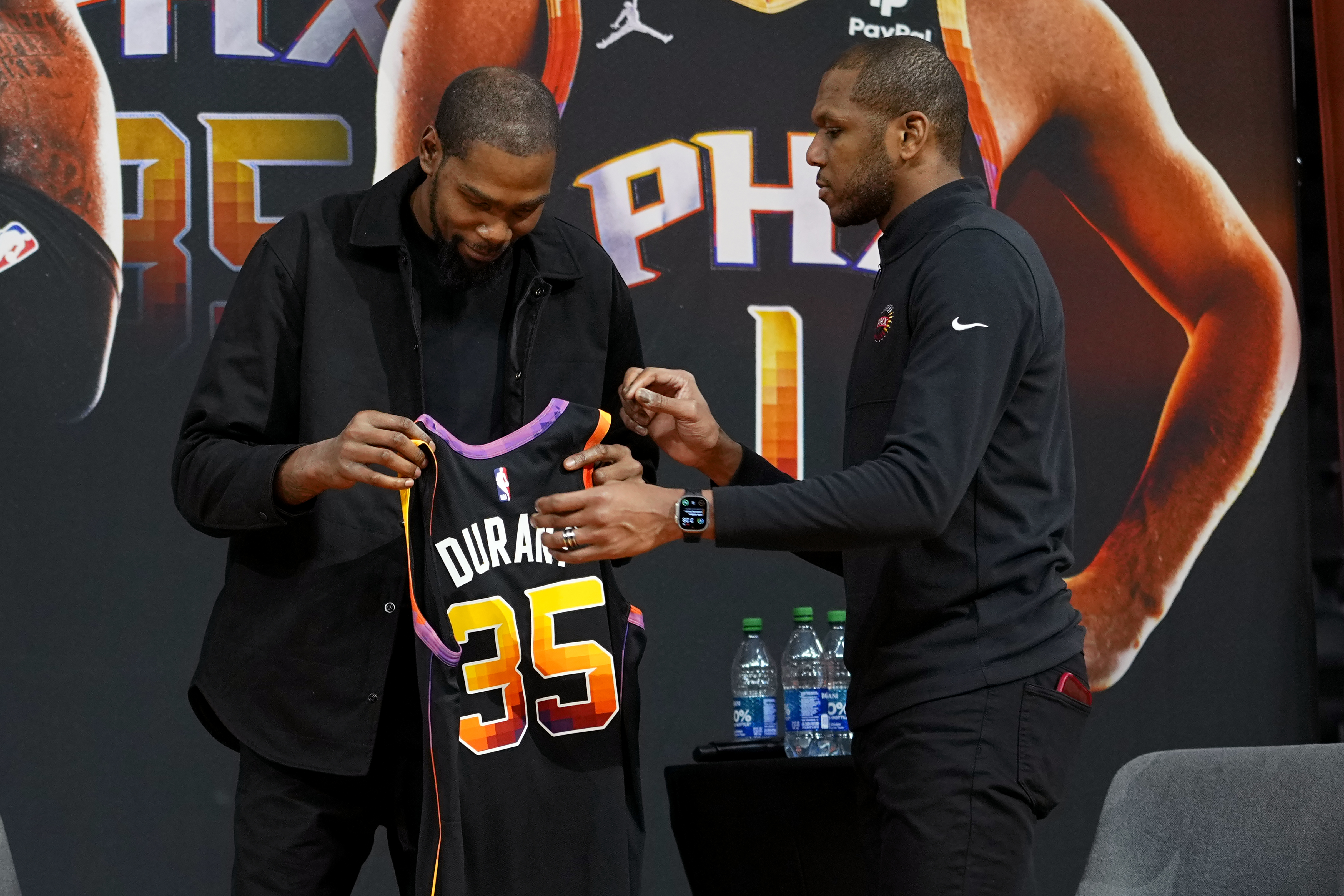 Phoenix Suns general manager James Jones gives forward Kevin Durant a jersey after being introduced during an NBA basketball team availability, Thursday, Feb. 16, 2023, in Phoenix. (AP Photo/Matt York)