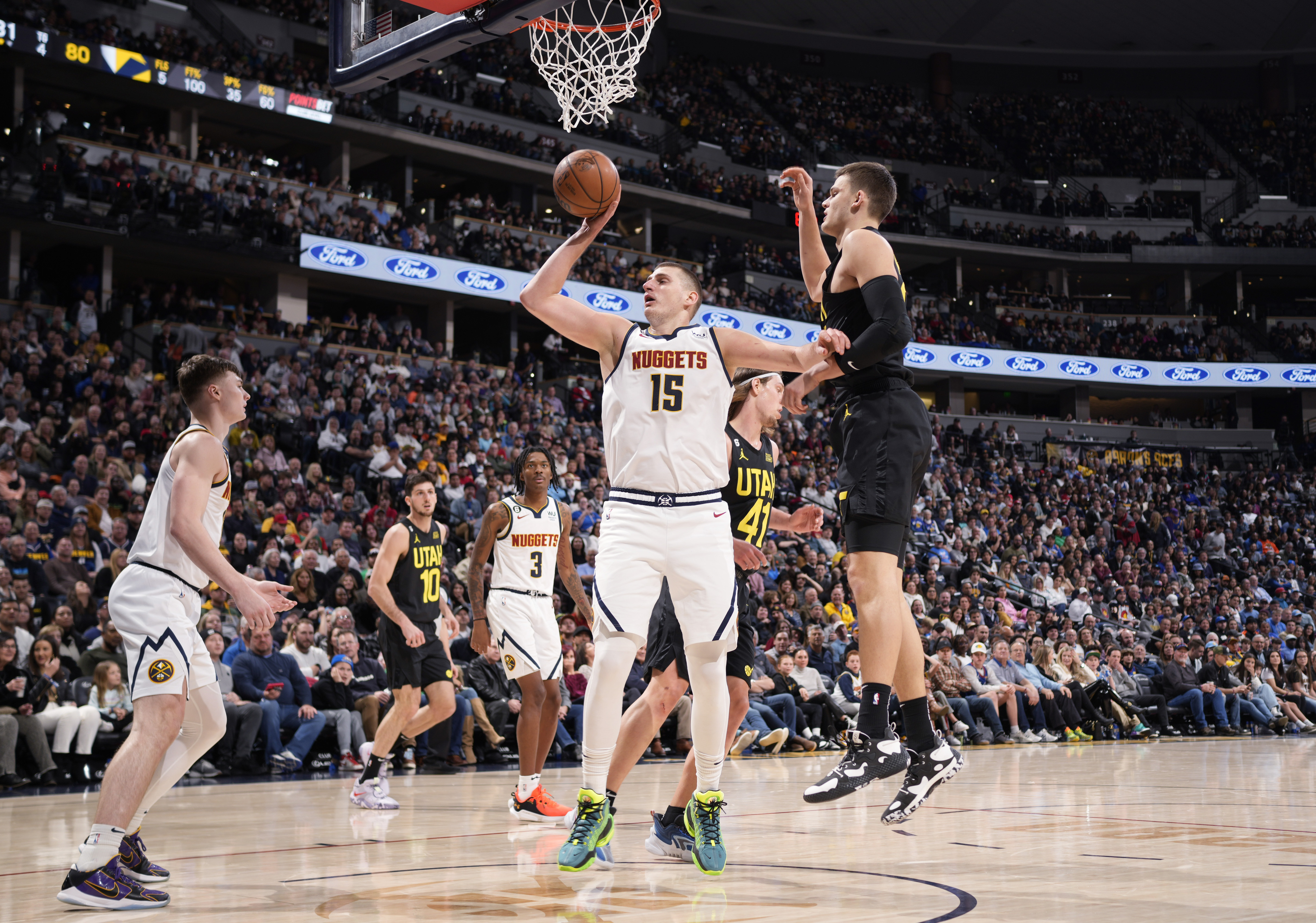 Denver Nuggets center Nikola Jokic (15) pulls down a rebound as Utah Jazz center Walker Kessler, right, defends in the second half of an NBA basketball game Saturday, Dec. 10, 2022, in Denver. (AP Photo/David Zalubowski)