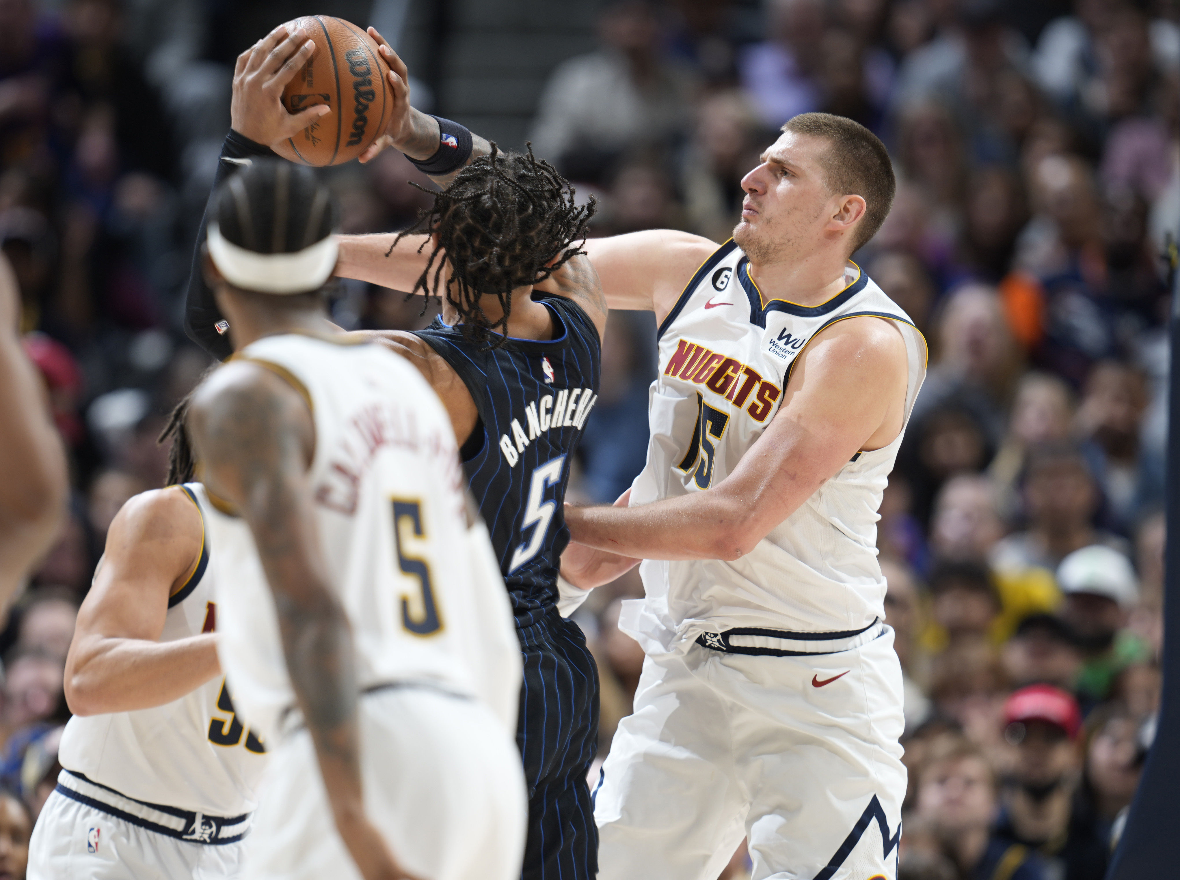 Denver Nuggets center Nikola Jokic, right, defends as Orlando Magic forward Paolo Banchero drives to the basket in the second half of an NBA basketball game Sunday, Jan. 15, 2023, in Denver. (AP Photo/David Zalubowski)