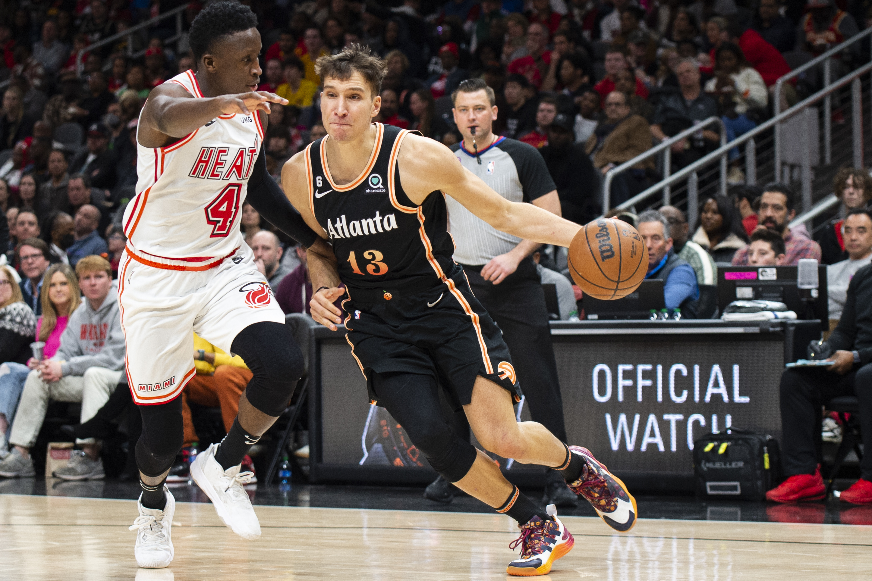 Atlanta Hawks guard Bogdan Bogdanovic, right, drives to the basket against Miami Heat guard Victor Oladipo during the second half of an NBA basketball game, Monday, Jan. 16, 2023, in Atlanta. (AP Photo/Hakim Wright Sr.)