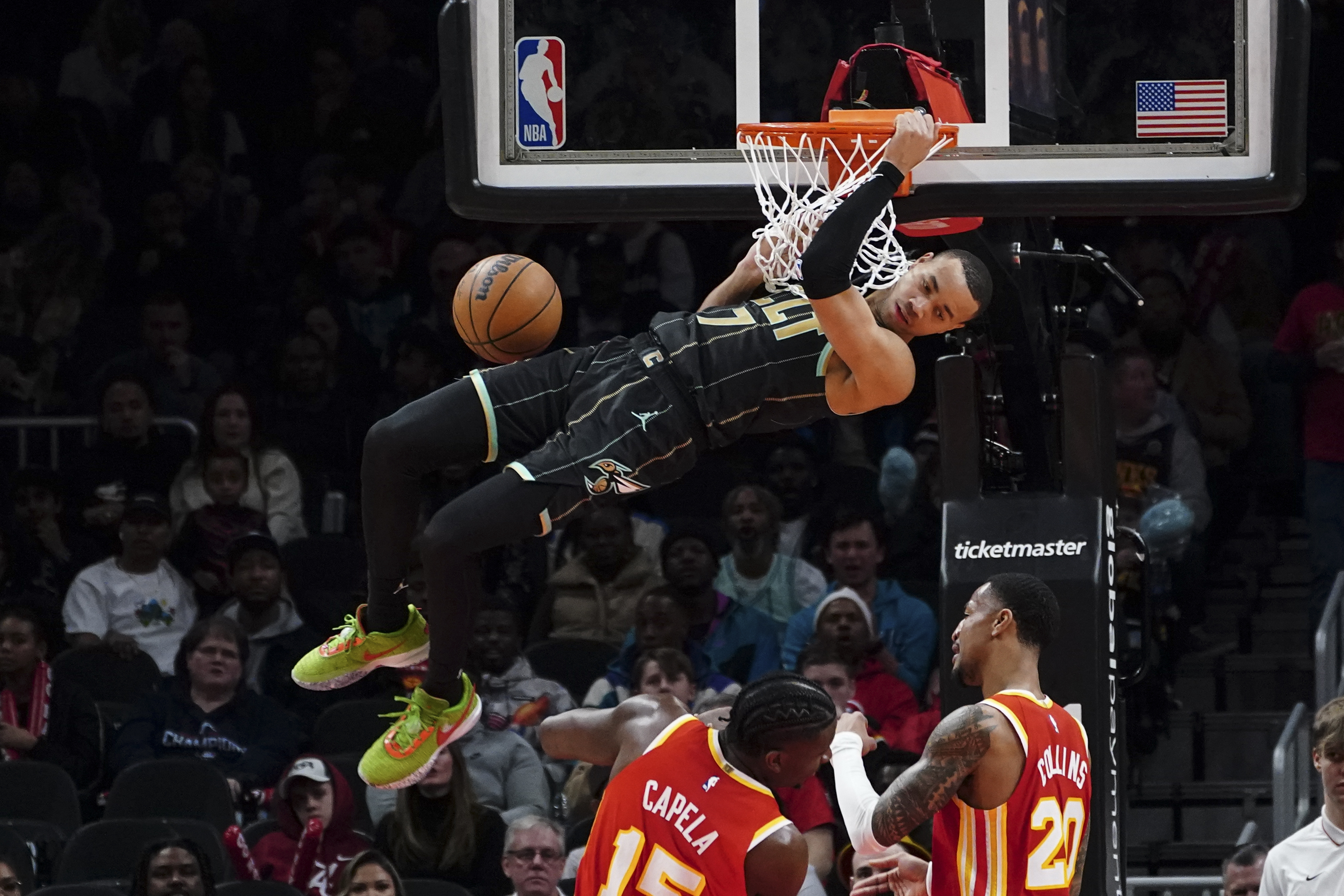 Charlotte Hornets guard Bryce McGowens (7) scores as Atlanta Hawks center Clint Capela (15) and forward John Collins (20) look on during the first half of an NBA basketball game Saturday, Jan. 21, 2023, in Atlanta. (AP Photo/John Bazemore)