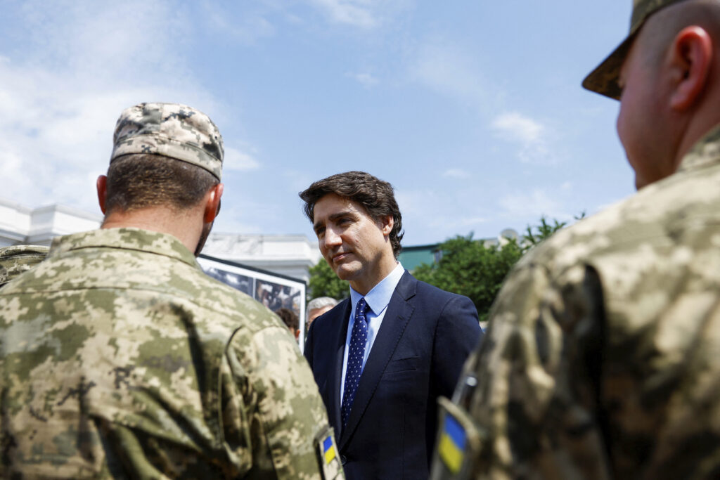 Canadian Prime Minister Justin Trudeau speaks with Ukrainian soldiers as he visits the Wall of Remembrance, in Kyiv, Ukraine, Saturday June 10, 2023. (Valentyn Ogirenko/Pool via AP)
