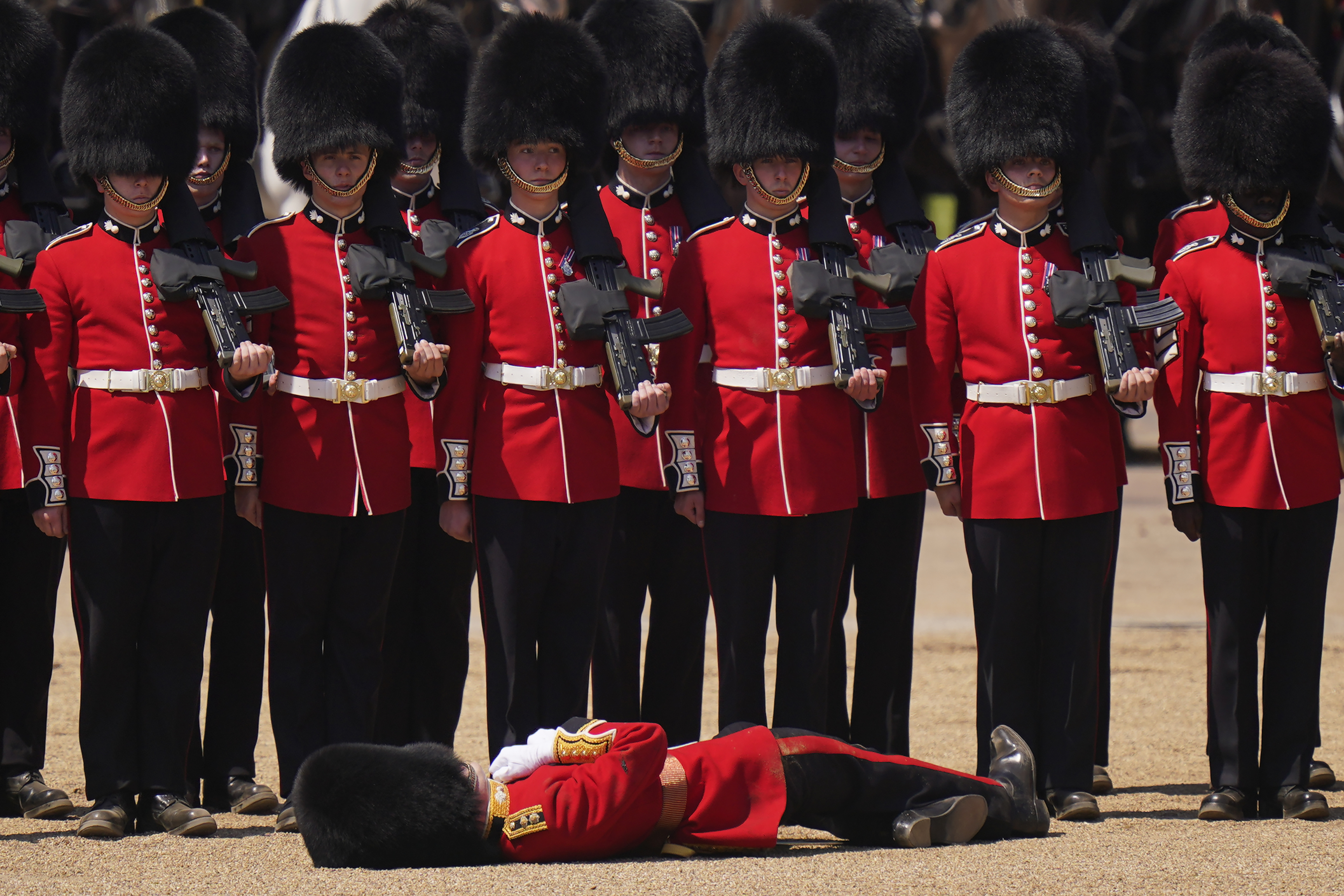 A soldier faints during the Colonel's Review, the final rehearsal of the Trooping the Colour, the King's annual birthday parade, at Horse Guards Parade in London, Saturday, June 10, 2023. (AP Photo/Alberto Pezzali)