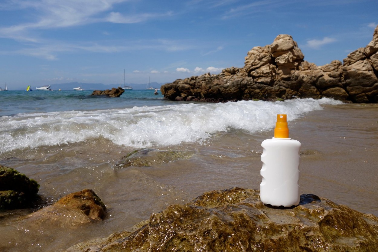 Sun cream bottle in front of the sea, in the beach