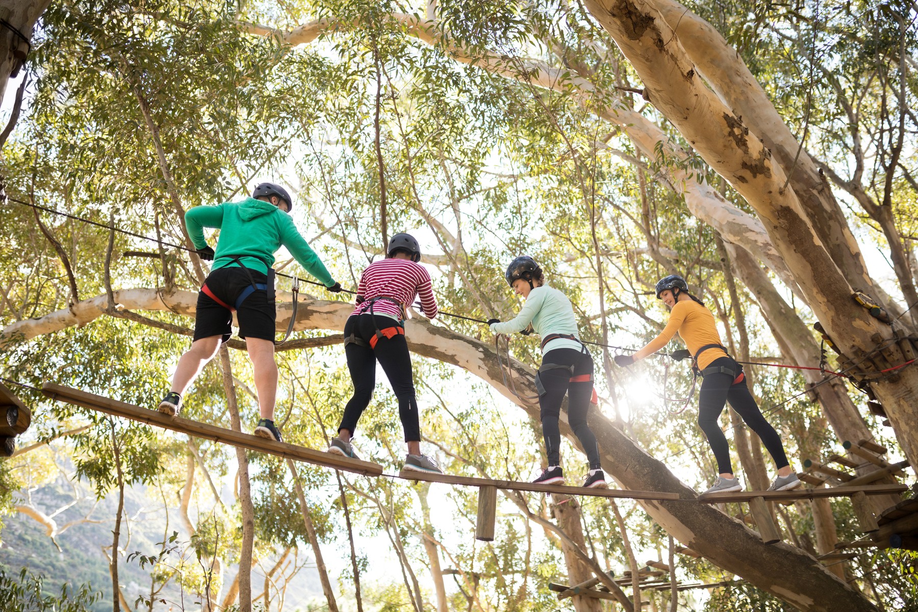Friends enjoying zip line adventure in park