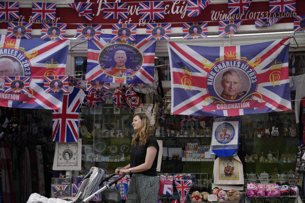 A woman looks at King Charles III coronation memorabilia on sale at a shop in Windsor, England, Friday, May 5, 2023. King Charles III will be crowned King at Westminster Abbey on Saturday May, 6. (AP Photo/Andrea Alexandru)