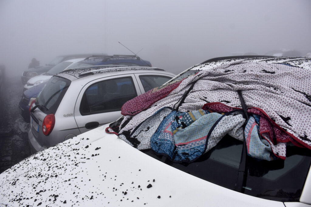 epa10643698 Copious volcanic ash on cars due to the eruptive activity of Etna Volcano on the square of the Rifugio Sapienza, Nicolosi, Sicily island, Italy, 21 May 2023.  EPA-EFE/ORIETTA SCARDINO