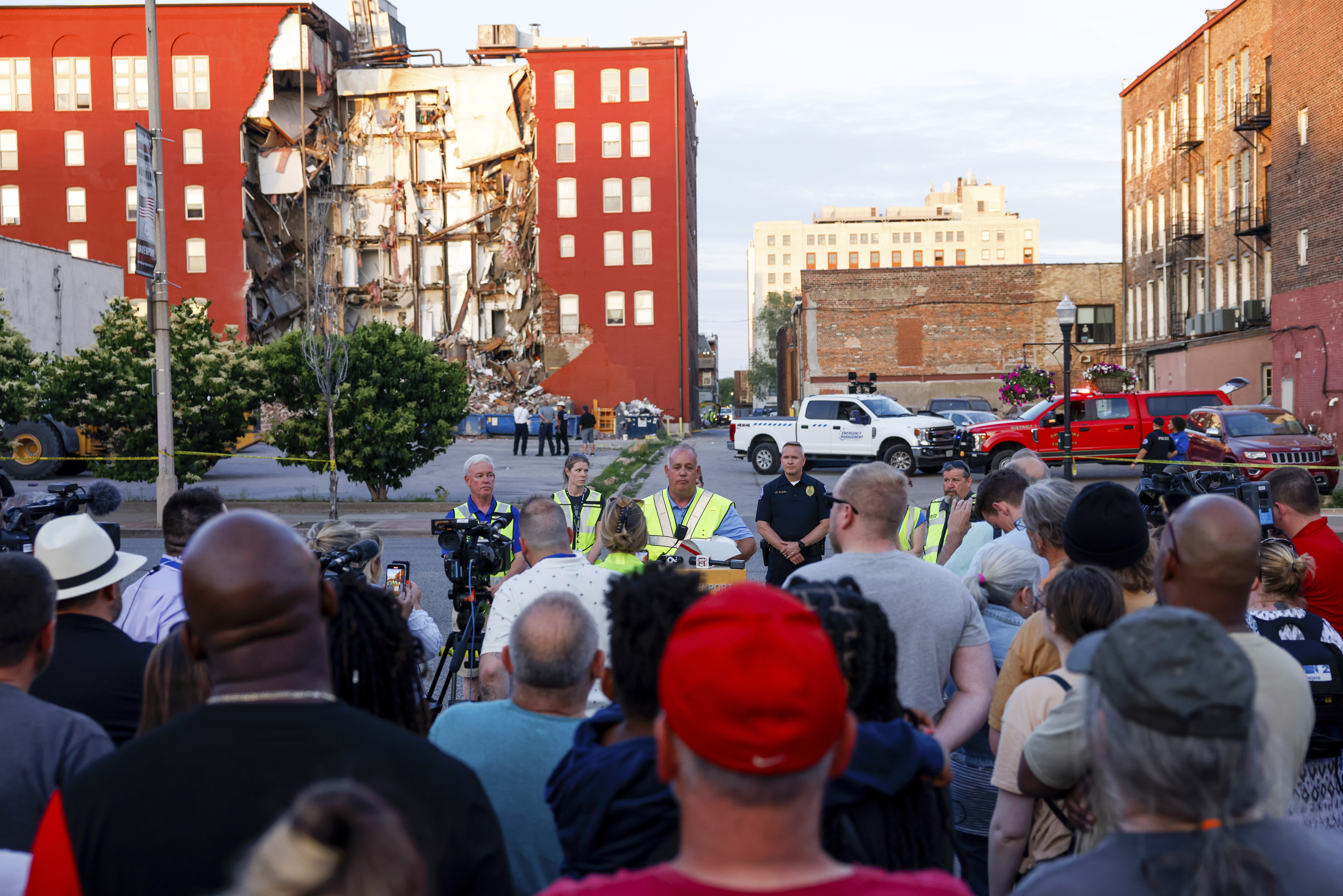 Officials update to media, residents and onlookers after a partial building collapse on the 300 block of Main Street, Sunday, May 28, 2023, in Davenport, Iowa. (Nikos Frazier/Quad City Times via AP)