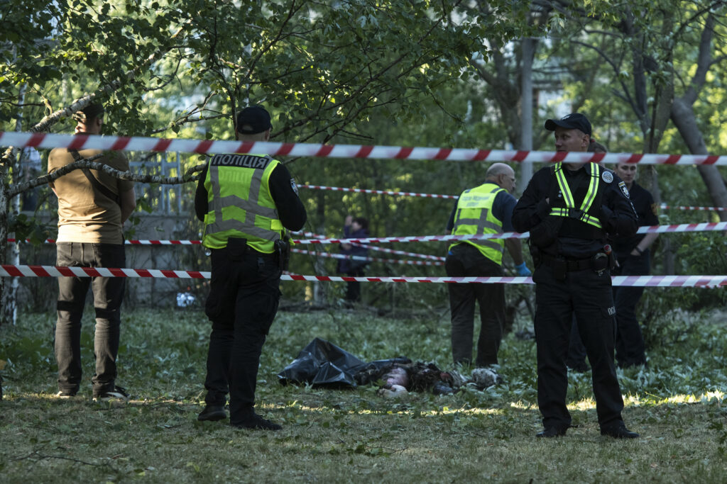 EDS NOTE: GRAPHIC CONTENT - Police officers inspect a dead body after an apparent Russian strike in Kyiv Ukraine, Thursday, June 1, 2023. (AP Photo/Wladyslaw Musiienko)