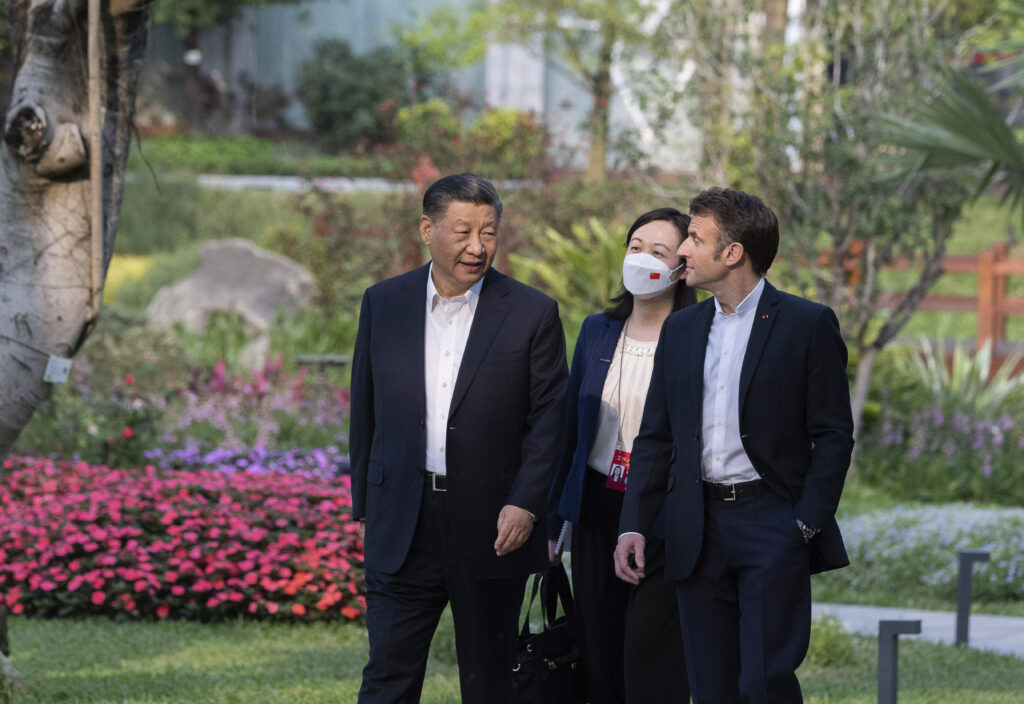Chinese President Xi Jinping, left, and French President Emmanuel Macron stroll in the garden of the Guandong province governor's residence, in Guangzhou, China, Friday, April 7, 2023. (Jacques Witt, Pool via AP)
