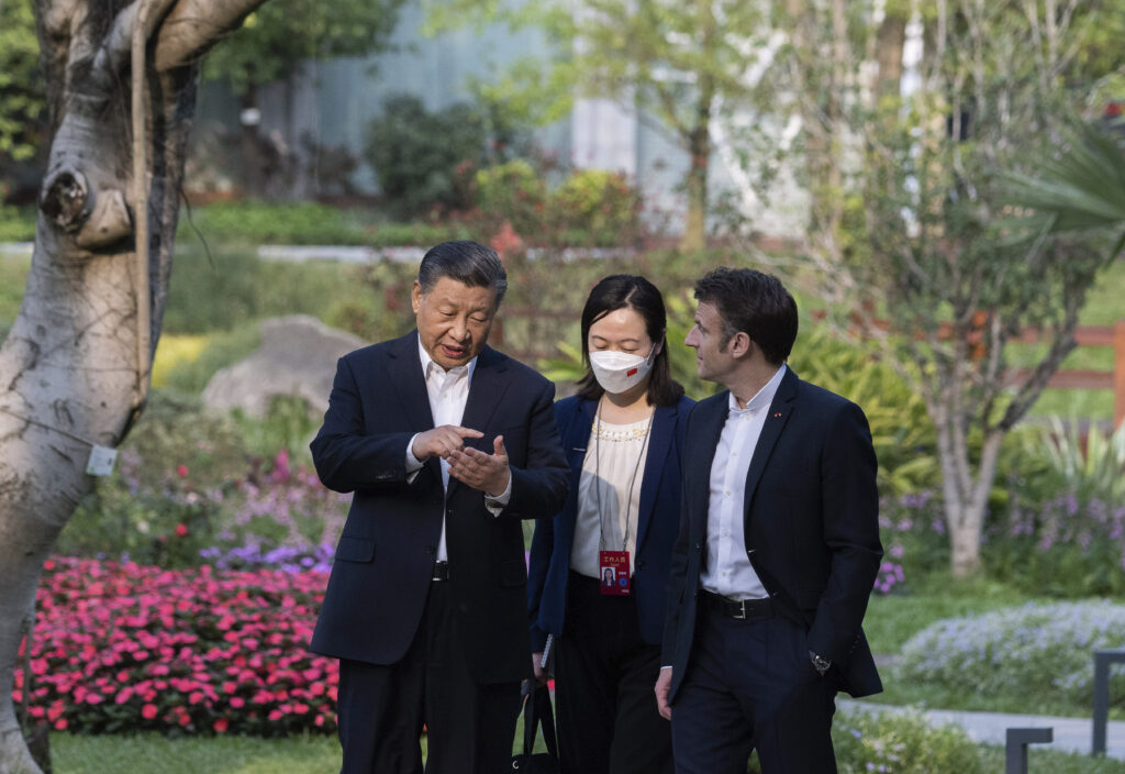 Chinese President Xi Jinping, left, and French President Emmanuel Macron talk in the garden of the Guandong province governor's residence, in Guangzhou, China, Friday, April 7, 2023. (Jacques Witt, Pool via AP)
