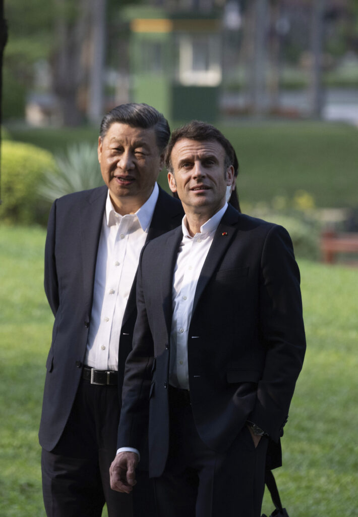 Chinese President Xi Jinping and French President Emmanuel Macron walk in the garden of the Guandong province governor's residence, in Guangzhou, China, Friday, April 7, 2023. (Jacques Witt, Pool via AP)