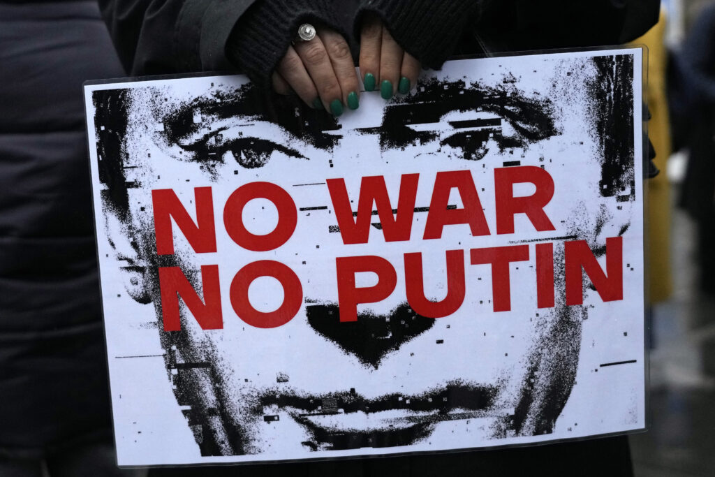 A woman holds a banner during a protest against the Russian invasion and in solidarity with the Ukrainian people, in Belgrade, Serbia, Saturday, Dec. 24, 2022. (AP Photo/Darko Vojinovic)
