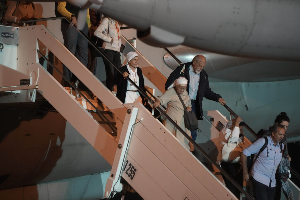People disembark from an Air Force plane carrying Italian citizens evacuated from Sudan landed at the Ciampino Military airport in Rome, Monday, April 24, 2023. (AP Photo/Gregorio Borgia)