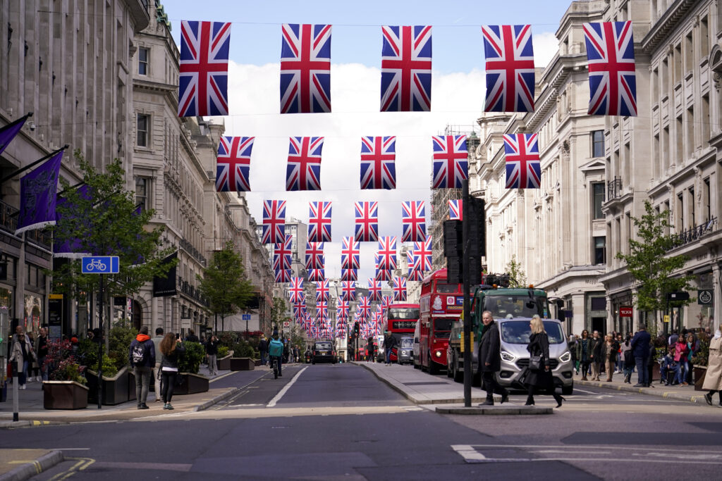 Regent Street is decorated with flags, ahead of the coronation of Britain's King Charles III, in London, Friday, April 28, 2023. (AP Photo/Alberto Pezzali)