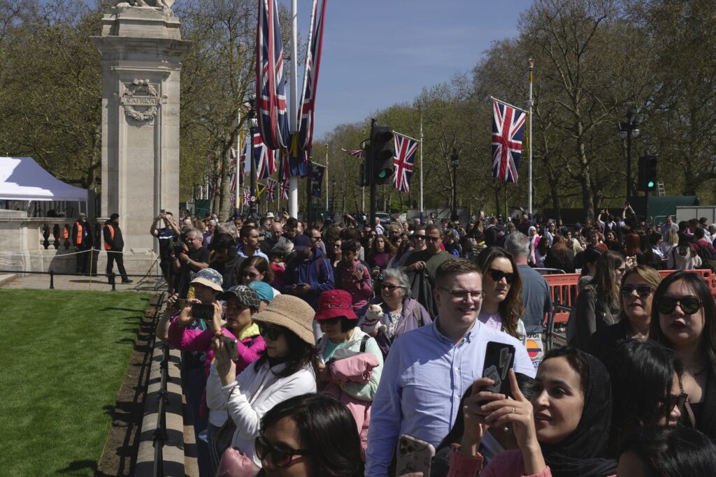 People take photographs in front of the Buckingham Palace ahead of the coronation of Britain's King Charles III, in Central London, Saturday, April 29, 2023. (AP Photo/Kin Cheung)