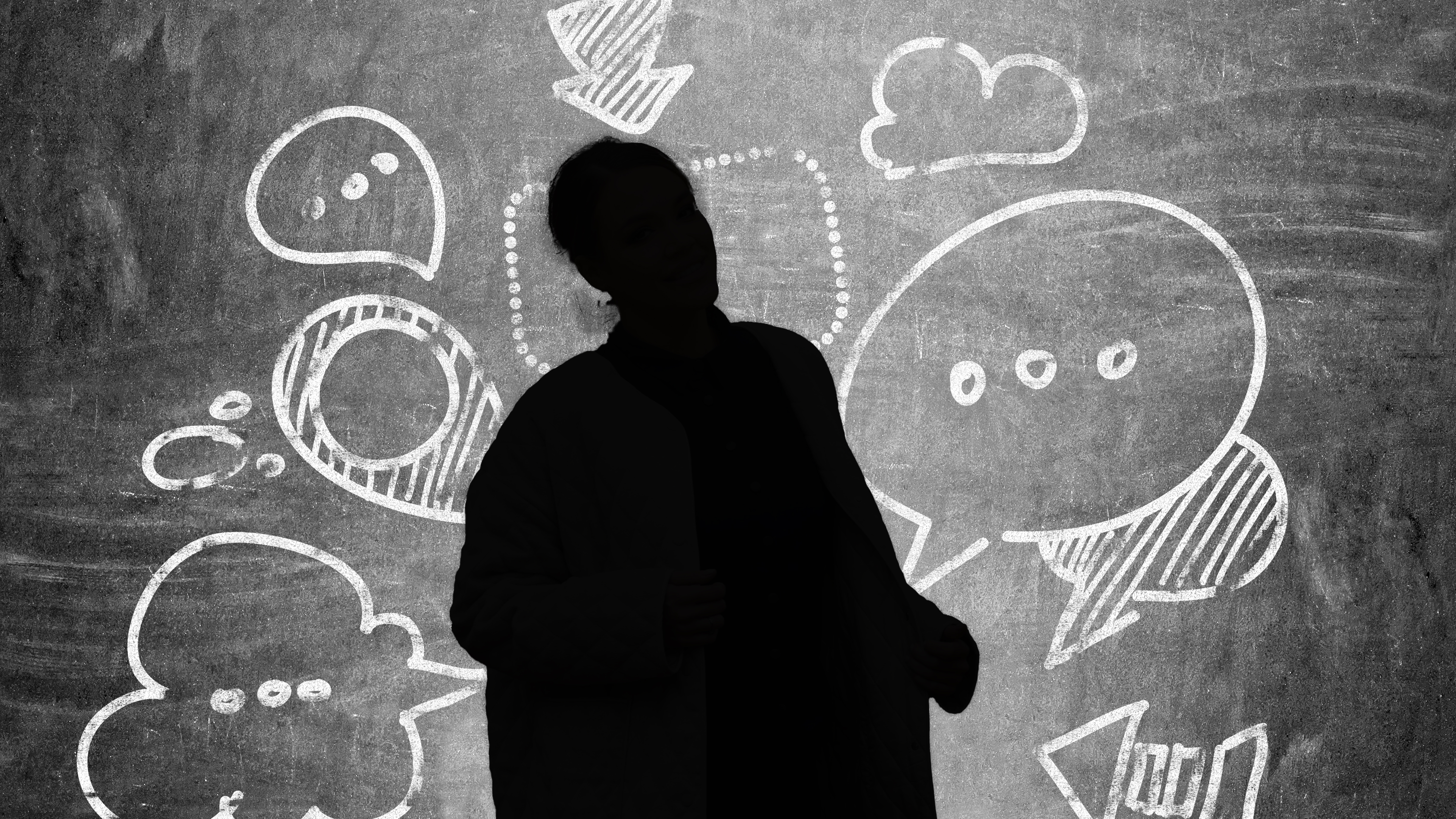 Businesswoman,With,Speech,And,Thought,Bubbles,On,Chalkboard