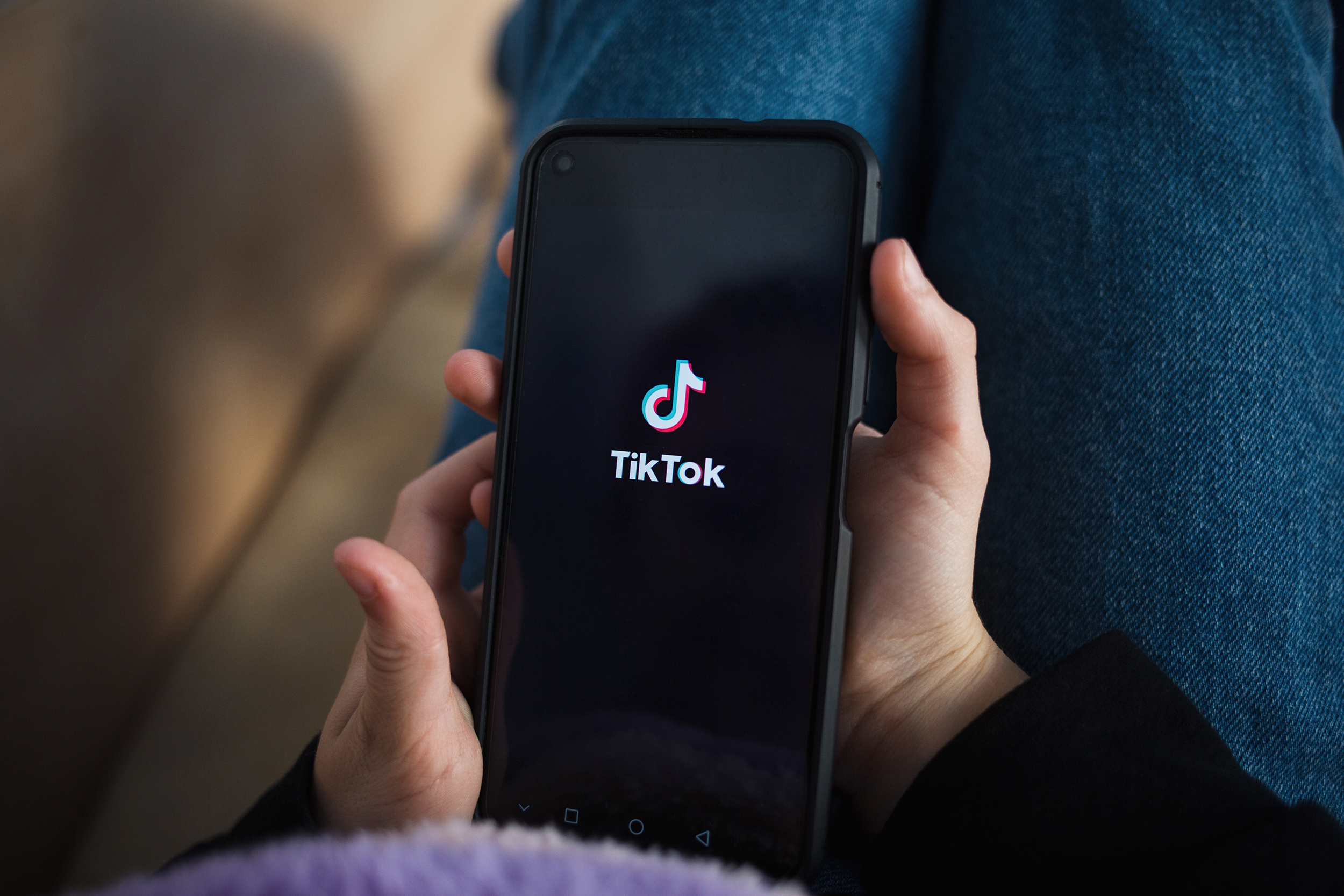 Nizhny Novgorod, Russia October 03 2020: child with phone in his hands is lying at home on bed. Social Media tiktok is loaded on screen.