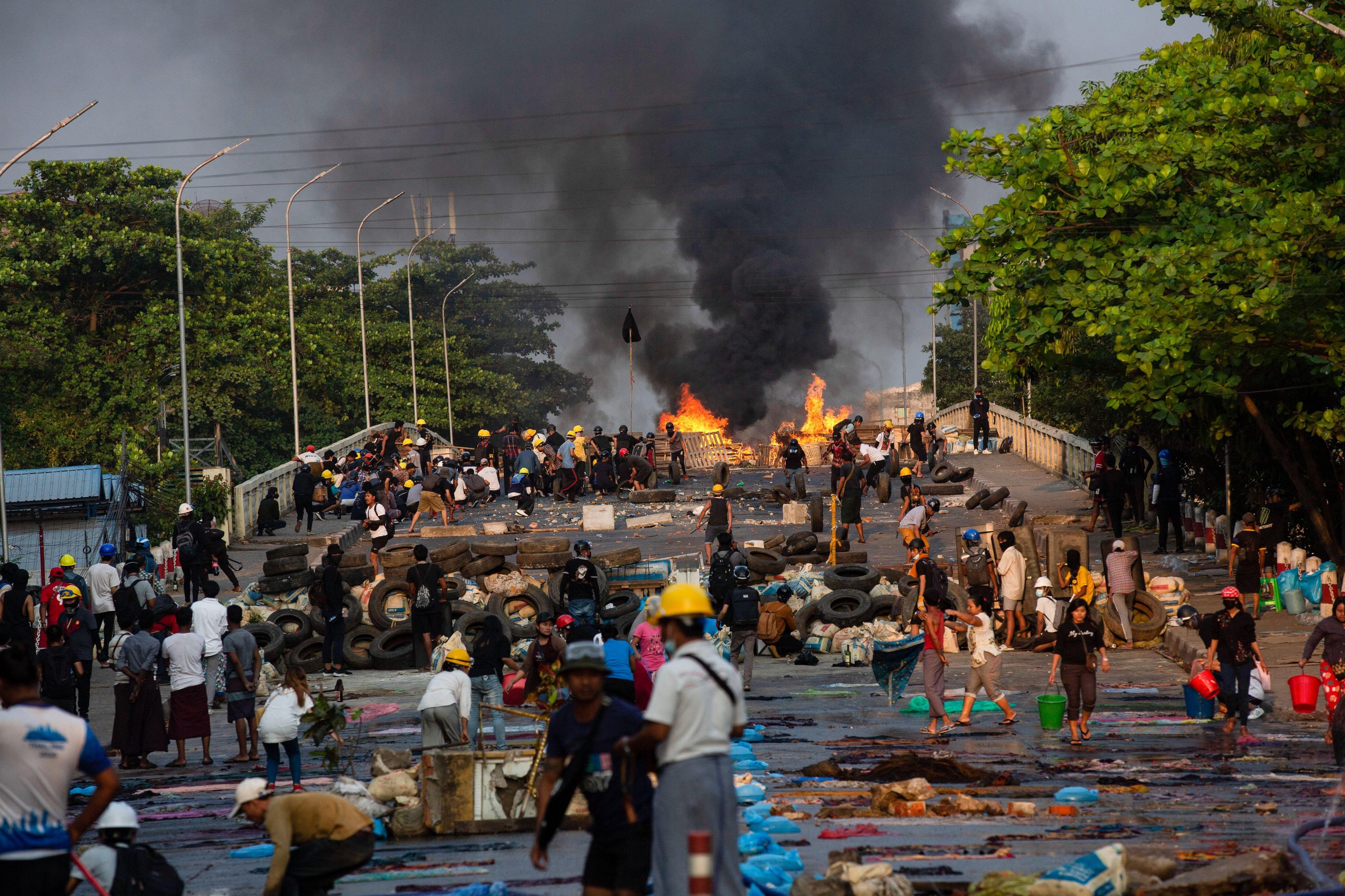 Chaotic scene of several makeshift barricades on a bridge to prevent police from coming with a burning barricade set on fire by the police during a demonstration against the military coup.Myanmar police attacked protesters with rubber bullets, live ammuni