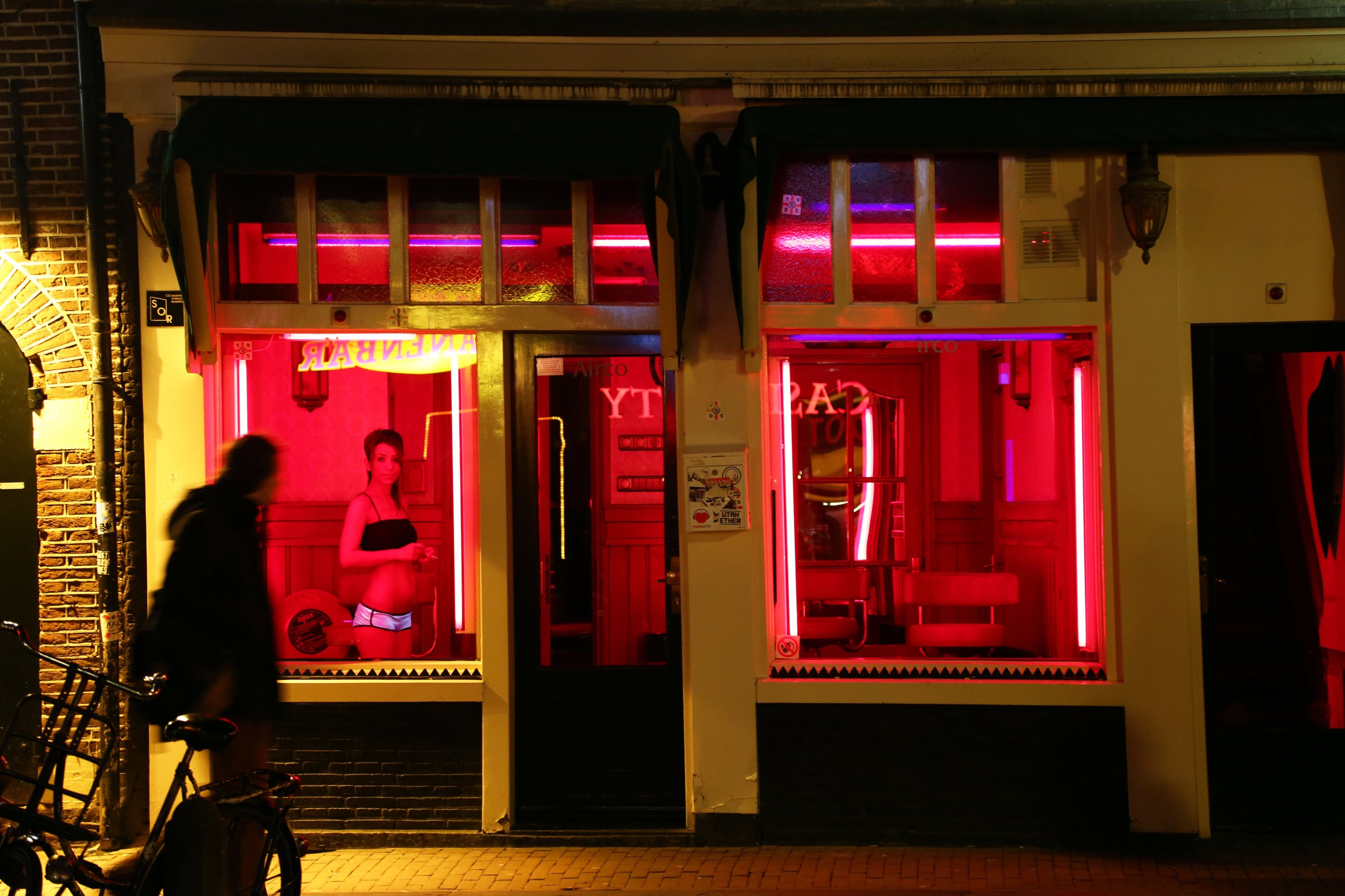 Red lights in the windows of houses along the canal of the Red Light District famous for prostitutes in Amsterdam