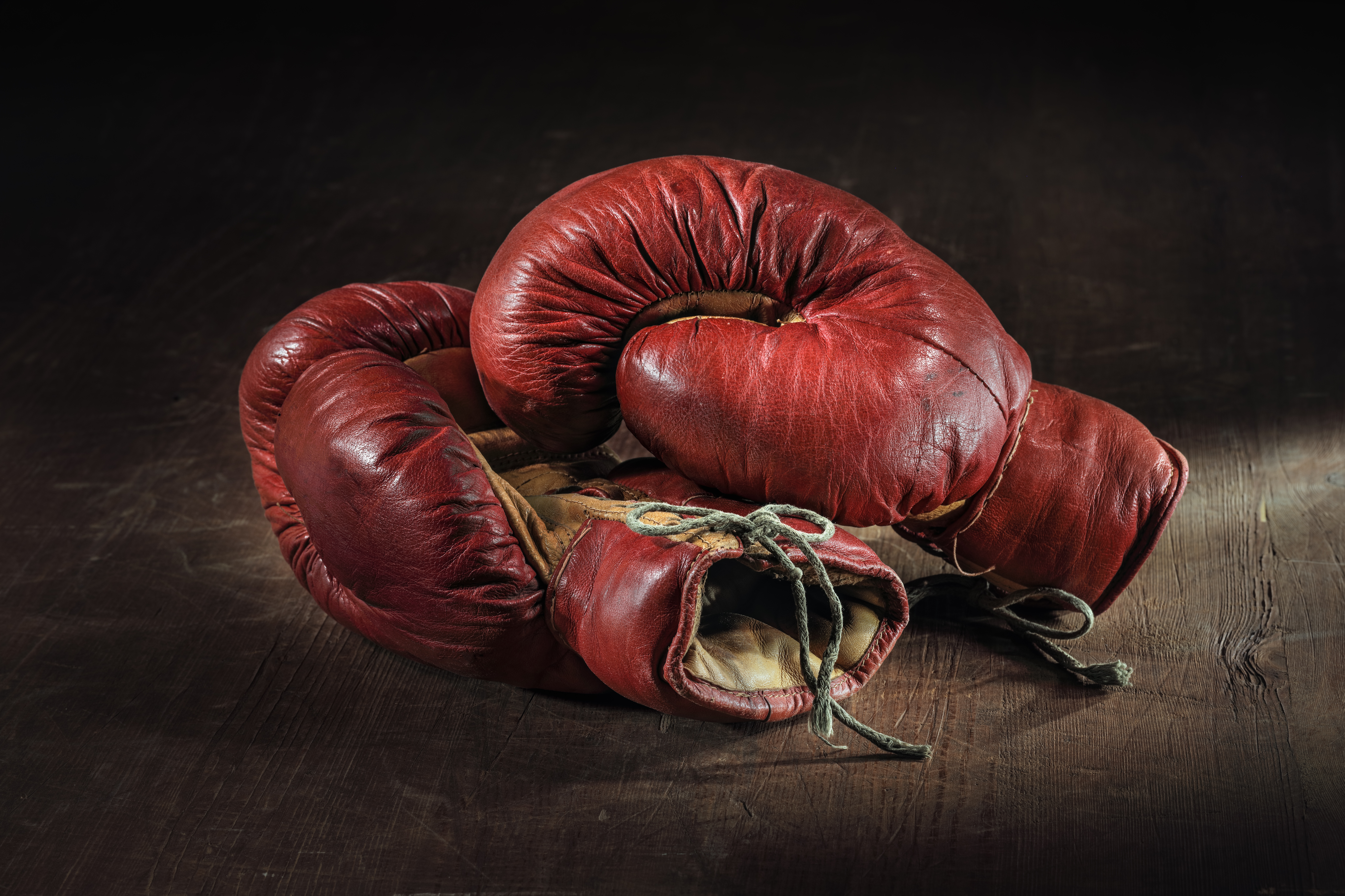 Old,Red,Boxing,Gloves,On,Wooden,Background.