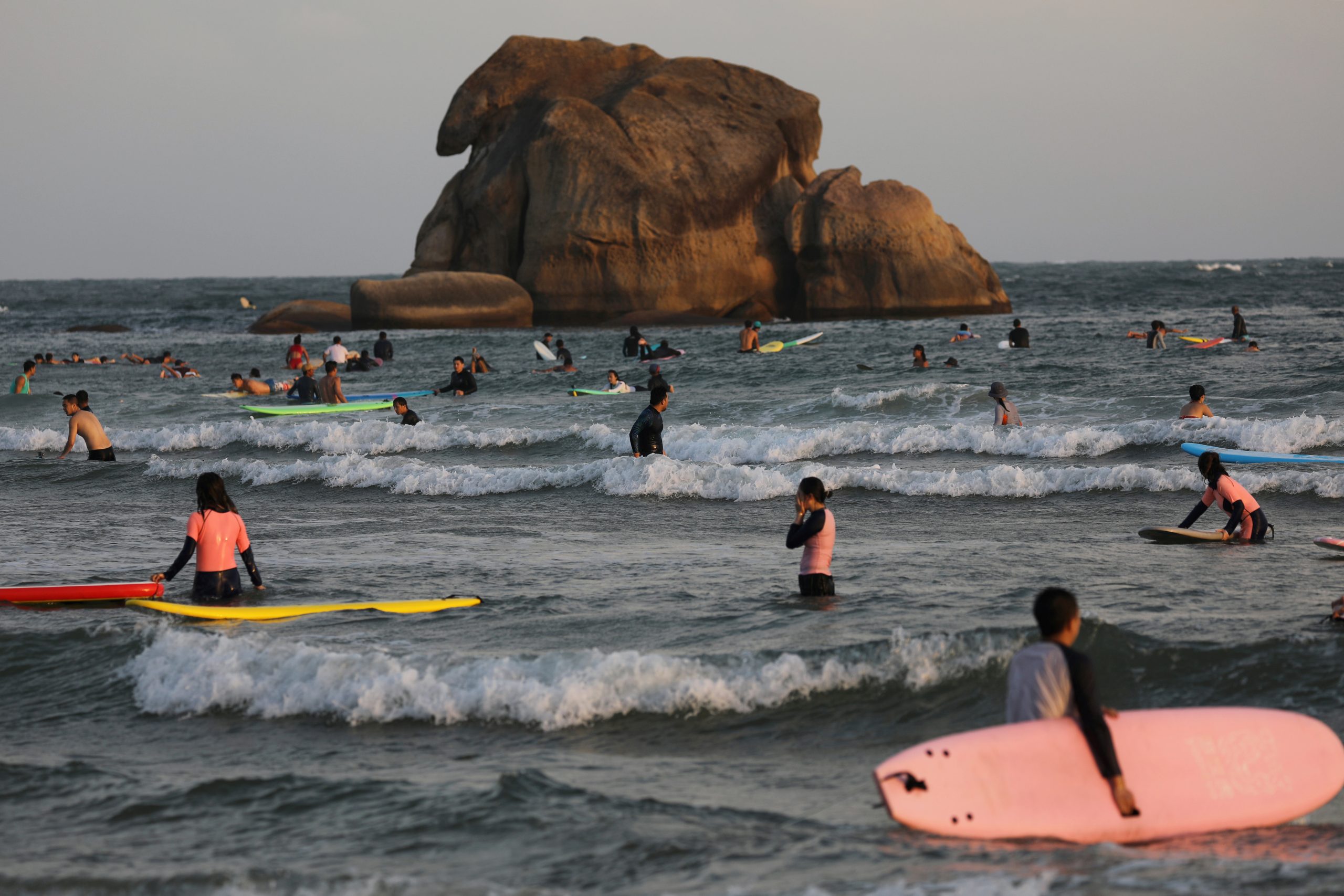 07122020 Surfers are seen in the sea in Sanya, Hainan province, China November 26, 2020. Picture taken November 26, 2020. REUTERS/Tingshu Wang