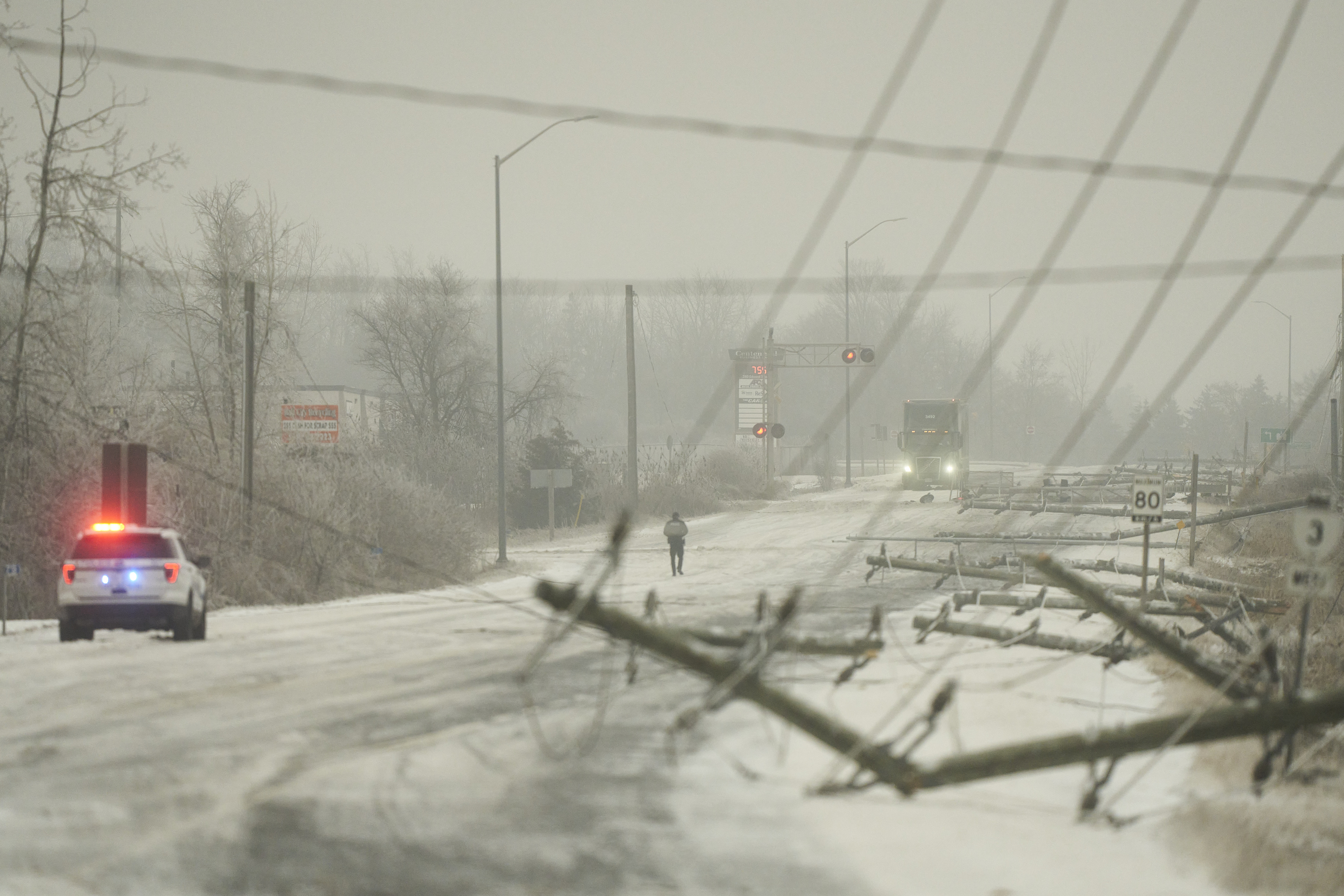 Electrical poles lay across Centennial Avenue in St.Thomas, Ont., Thursday, Feb. 23, 2023. A winter storm brought significant freezing rain to the region causing power outages, travel delays and school closures.  (Geoff Robins /The Canadian Press via AP)
