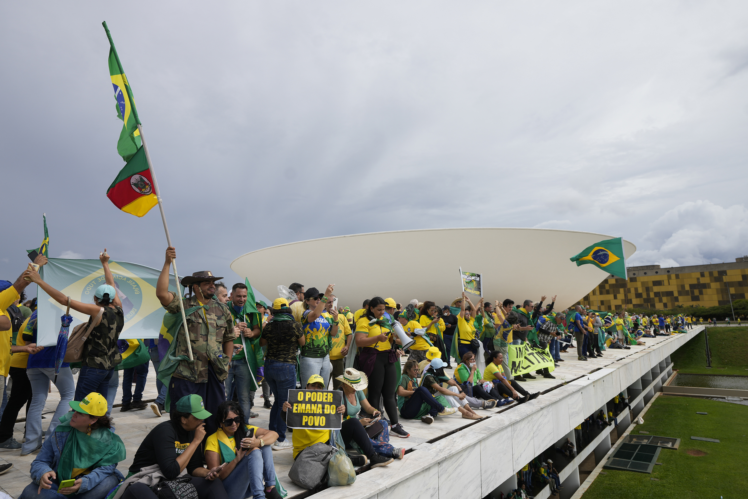 Protesters, supporters of Brazil's former President Jair Bolsonaro, stand on the roof of the National Congress building after they stormed it, in Brasilia, Brazil, Sunday, Jan. 8, 2023. (AP Photo/Eraldo Peres)