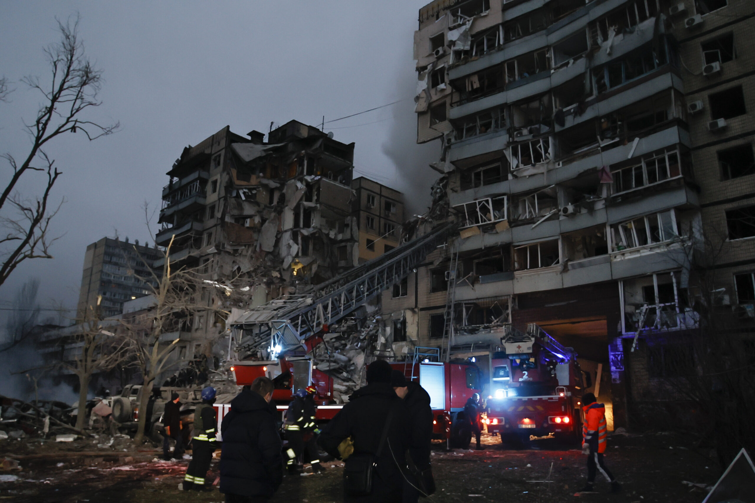 Emergency workers clear the rubble after a Russian rocket hit a multistory building leaving many people under debris in Dnipro, Ukraine, Saturday, Jan. 14, 2023. (AP Photo/Roman Chop)