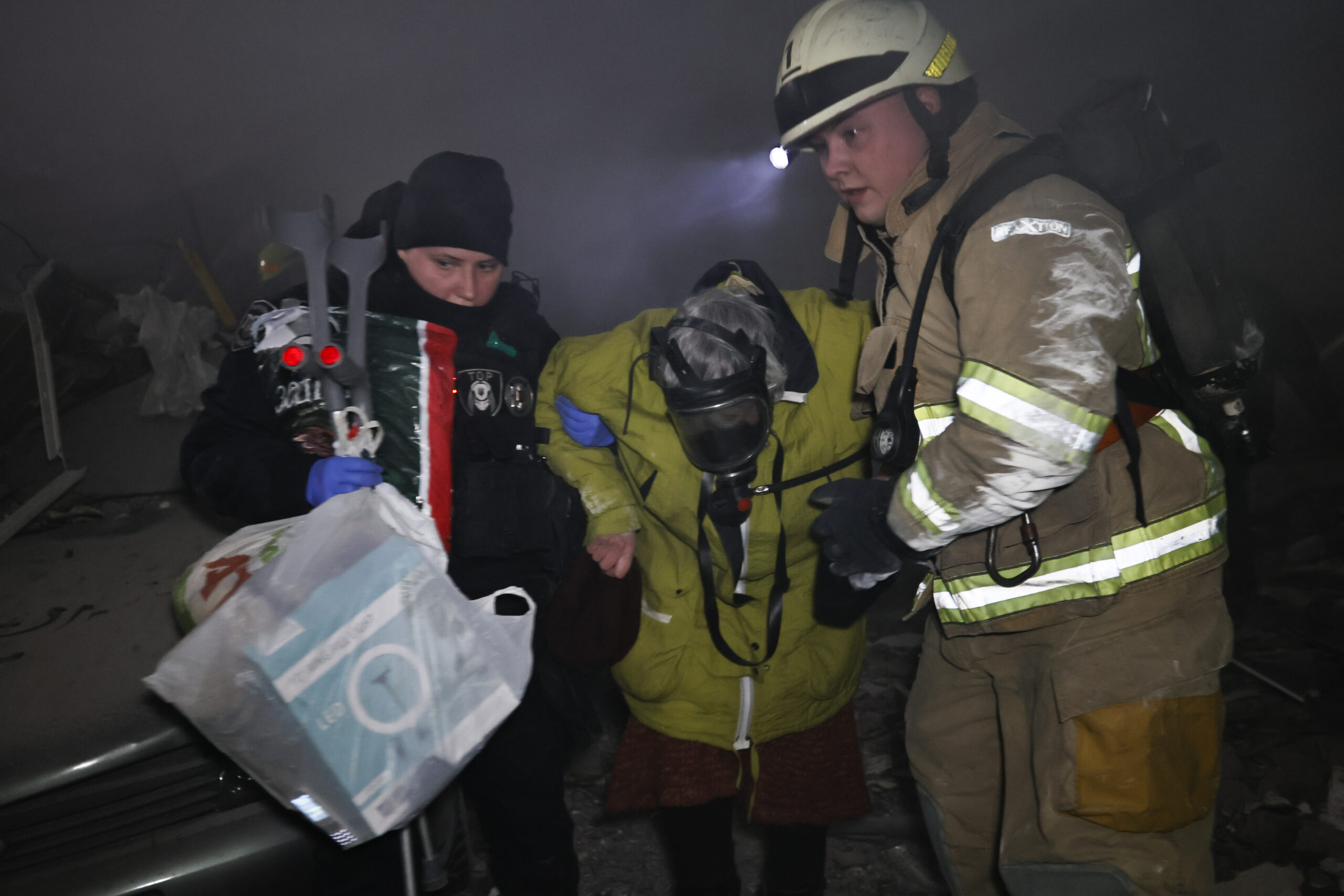 Emergency workers evacuate an elderly woman resident of a multistory building hit by a Russian rocket leaving many people under debris in Dnipro, Ukraine, Saturday, Jan. 14, 2023. (AP Photo/Roman Chop)
